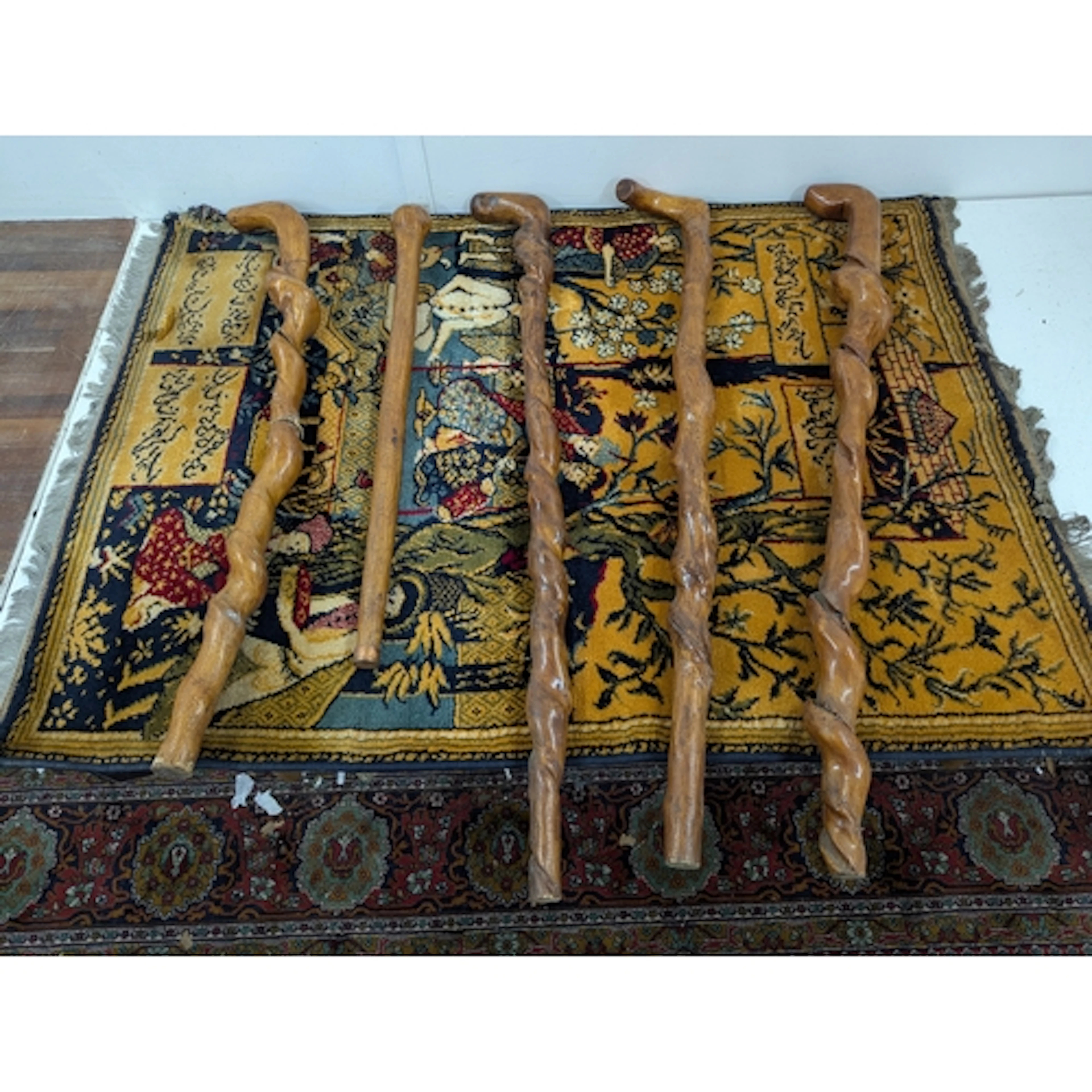 Five walking sticks and a modern Indian style rug depicting ...