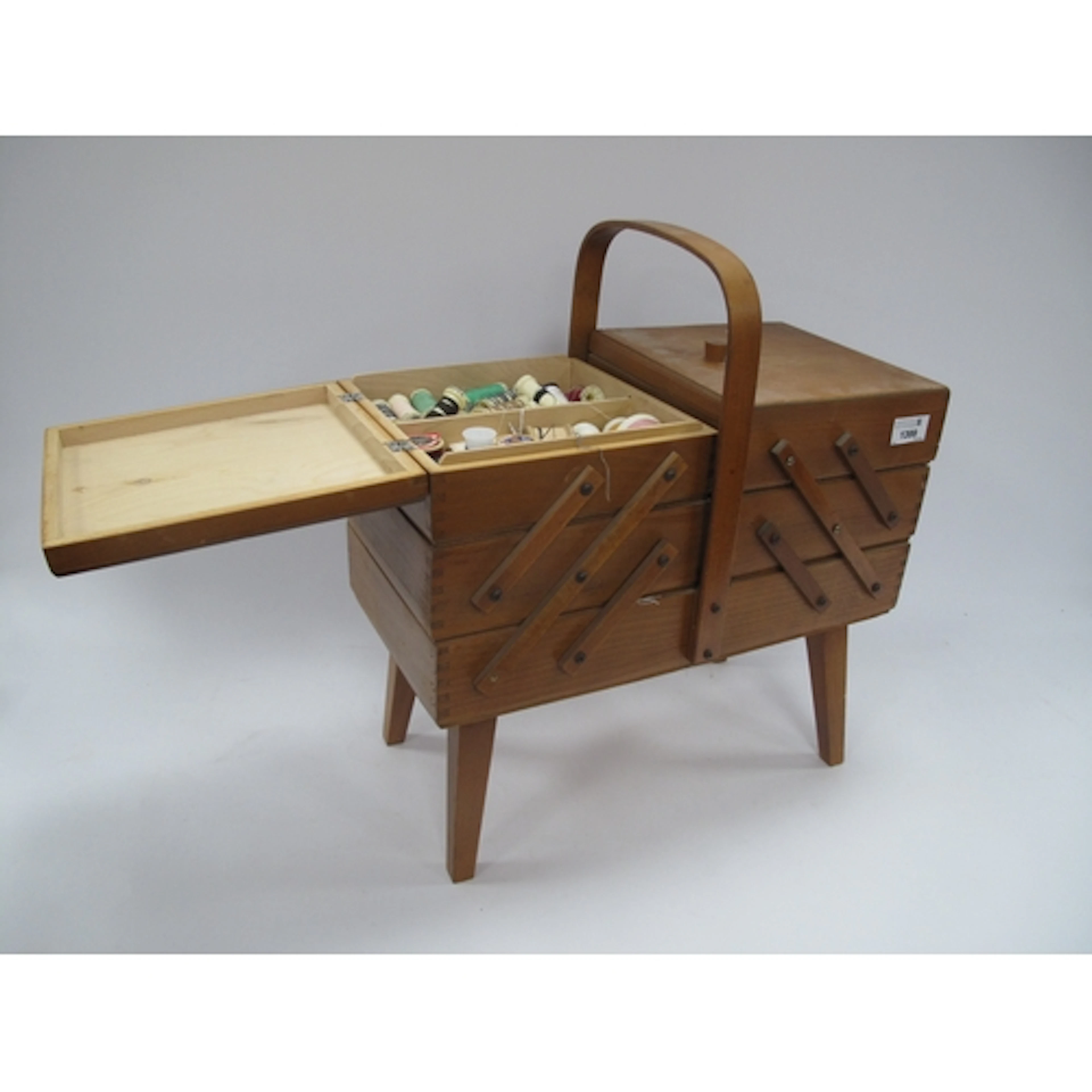 A vintage wooden accordion-style sewing box features multipl...