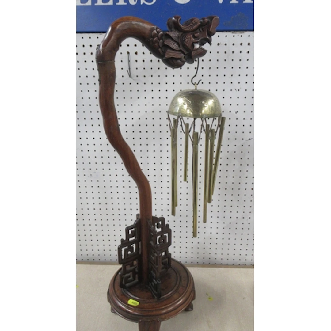 An Eastern hardwood chime stand, carved with a dragons head,...