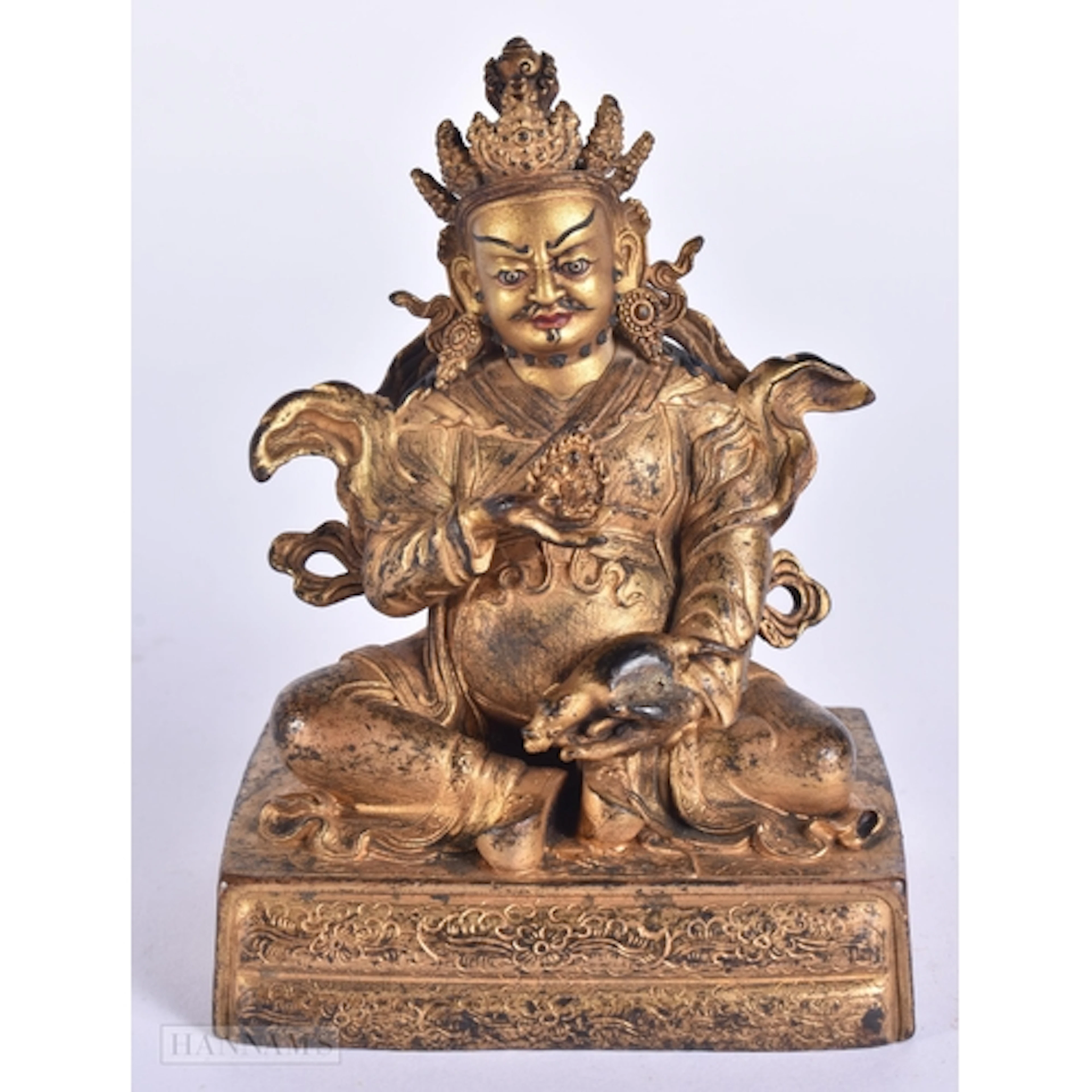 A TIBETAN BRONZE FIGURE OF A SEATED BUDDHA modelled upon a b...