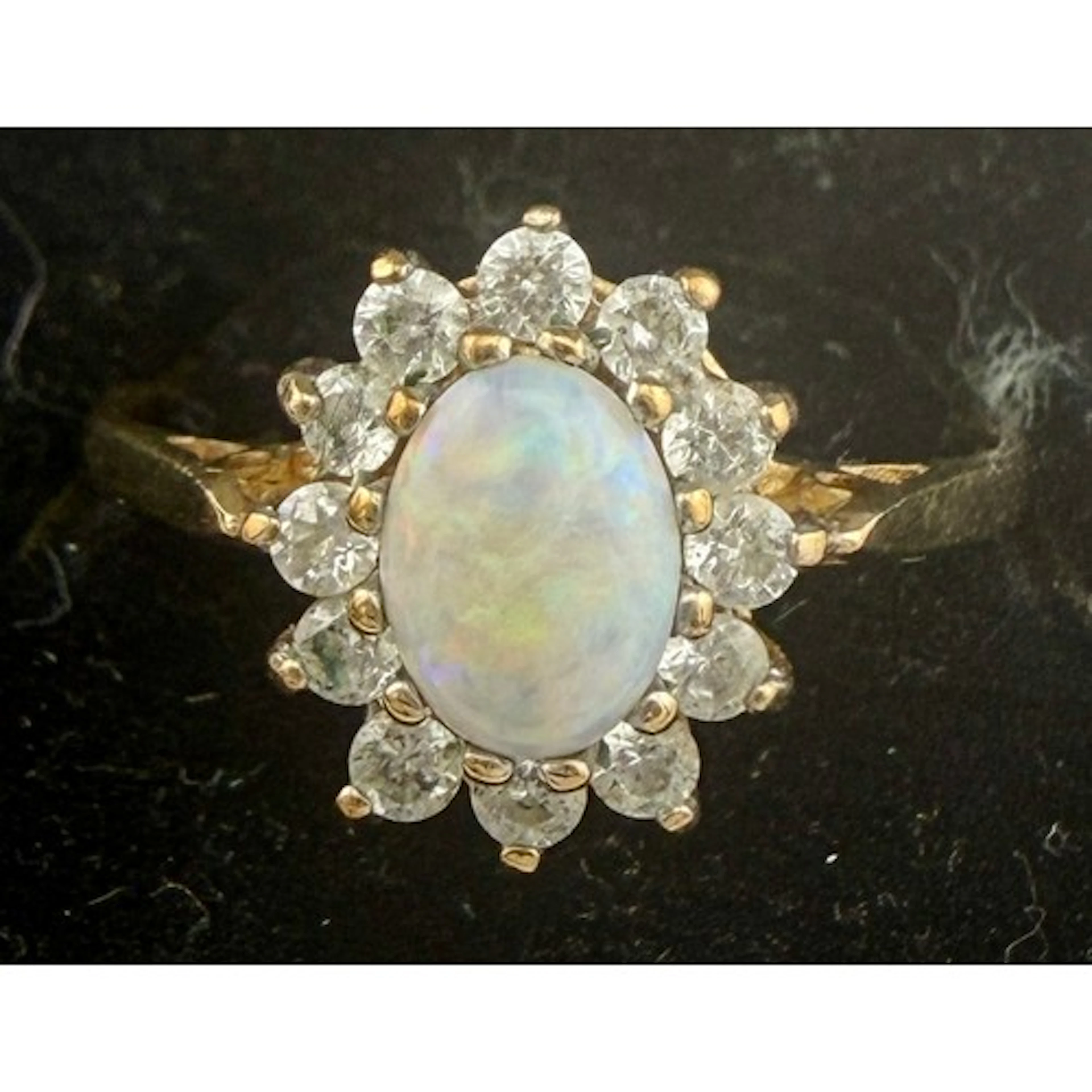 A 9 carat gold cluster ring set with opal and clear stones. ...