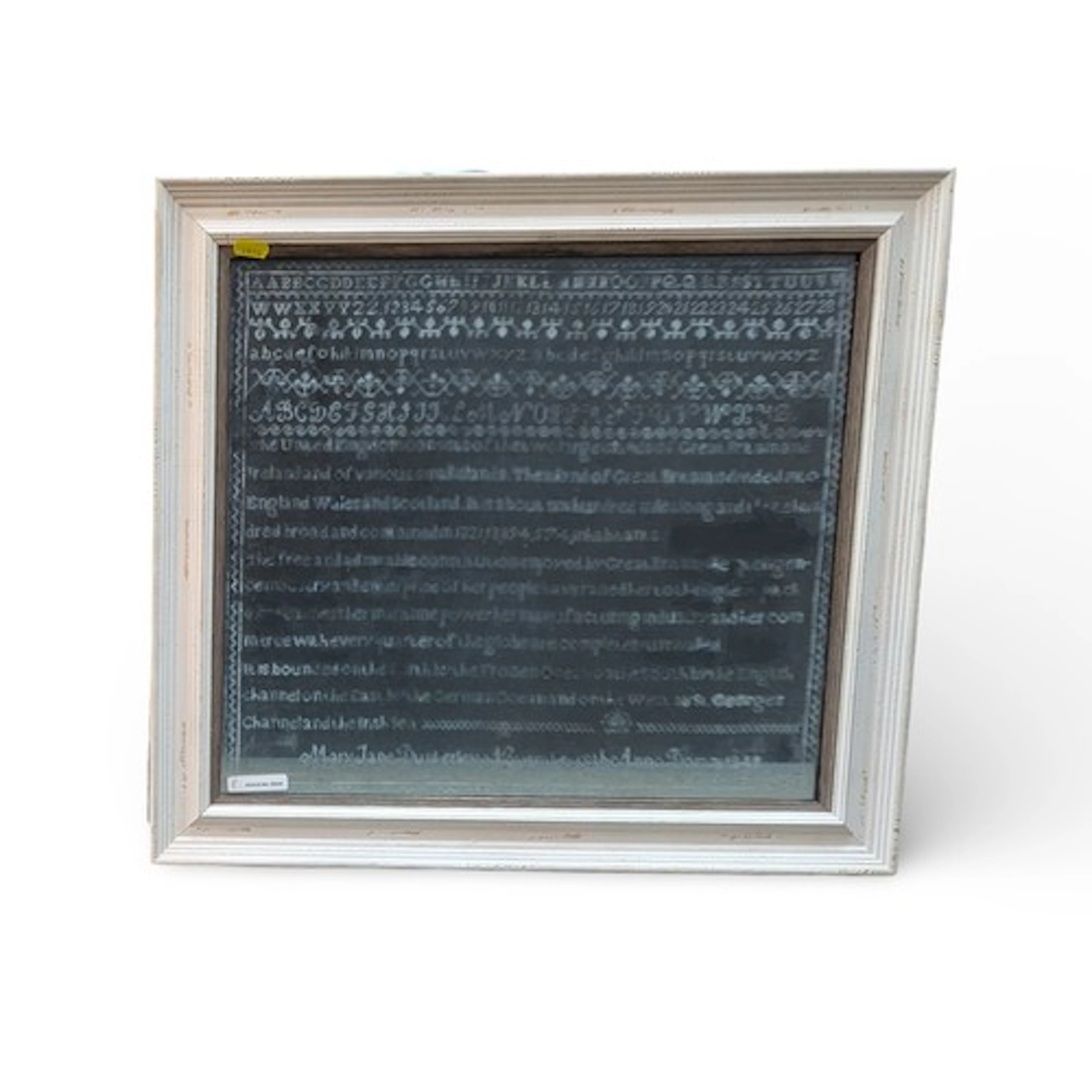 Glass etched with the image of an 1840's sampler, backed wit...