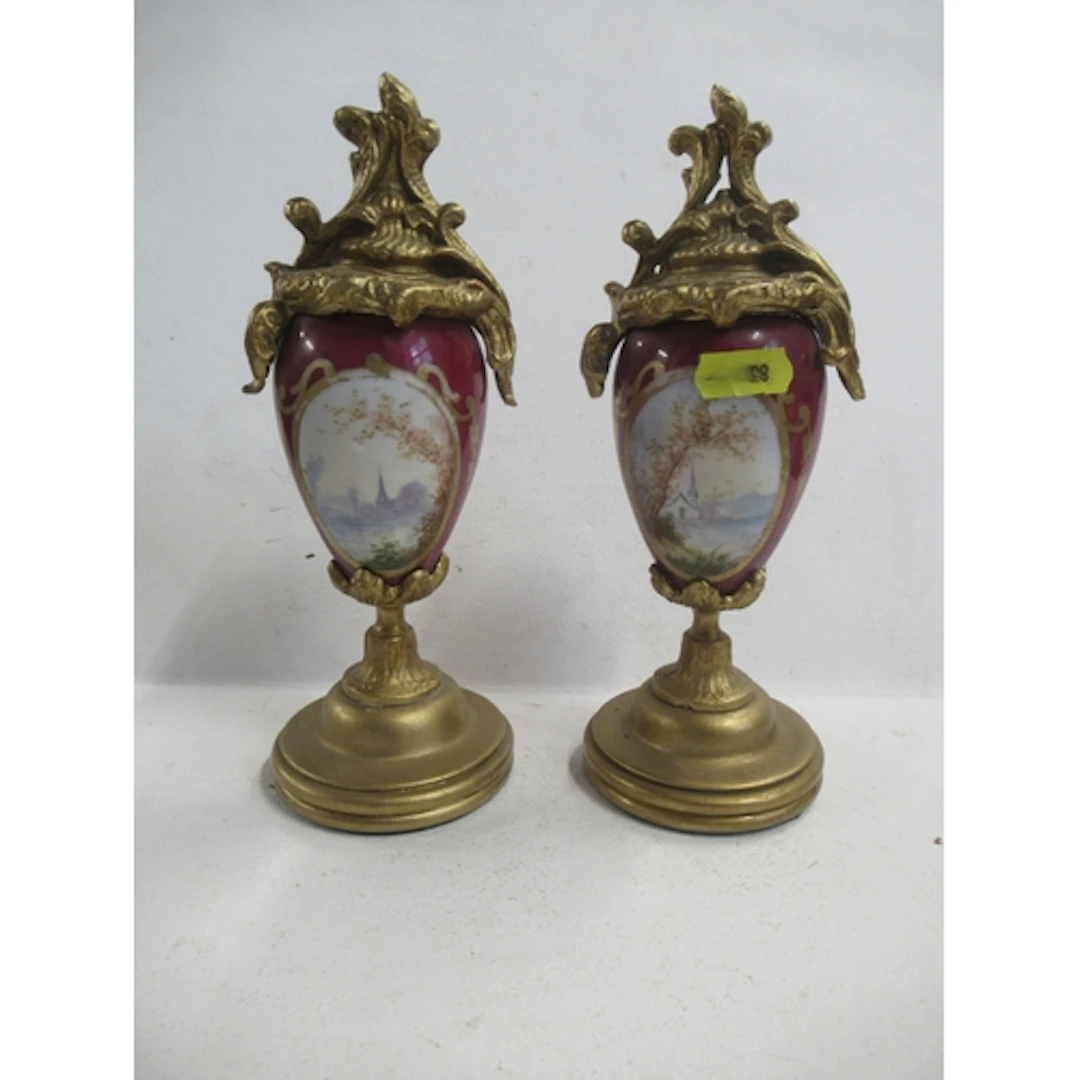A pair of ornaments, the porcelain body decorated with oval ...