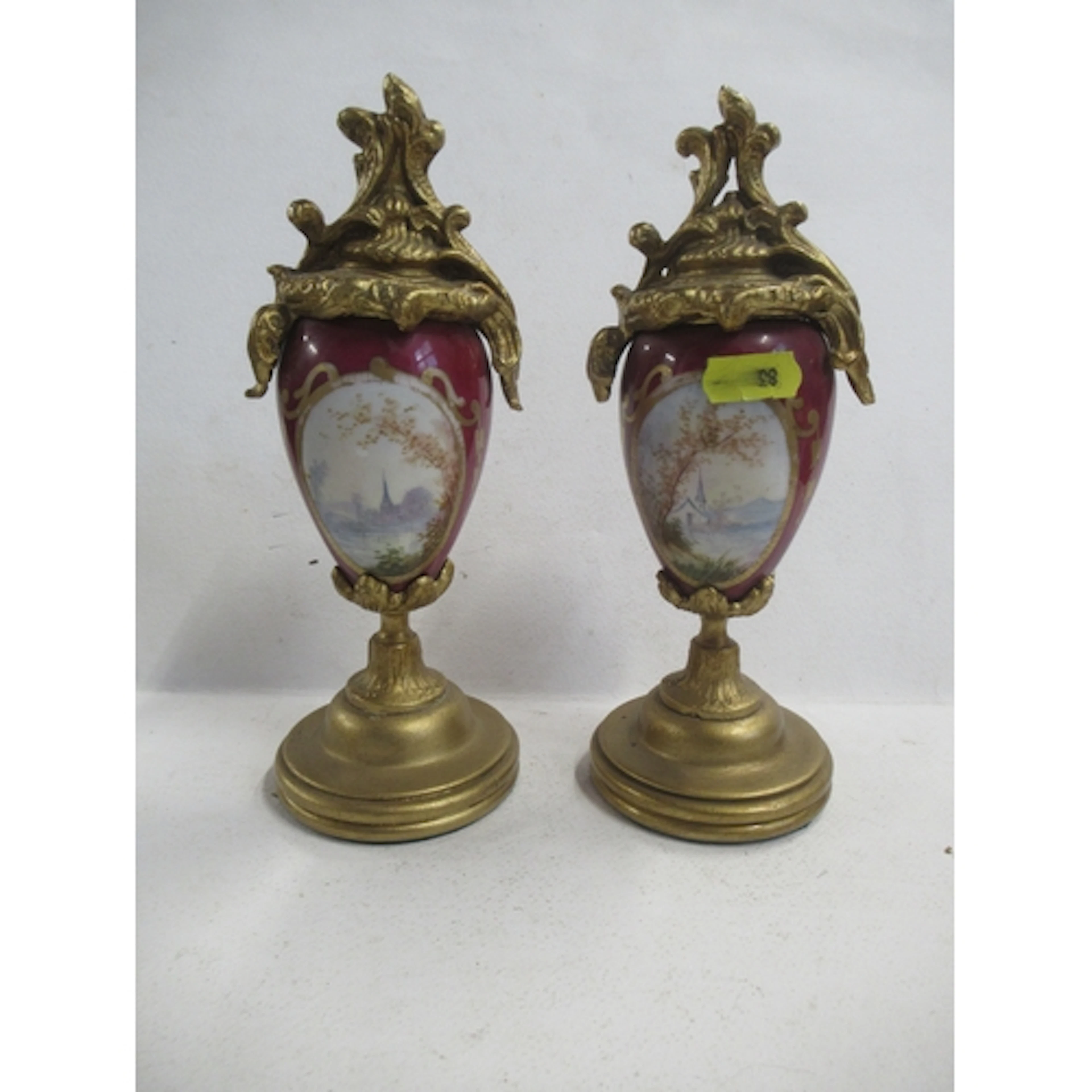 A pair of ornaments, the porcelain body decorated with oval ...