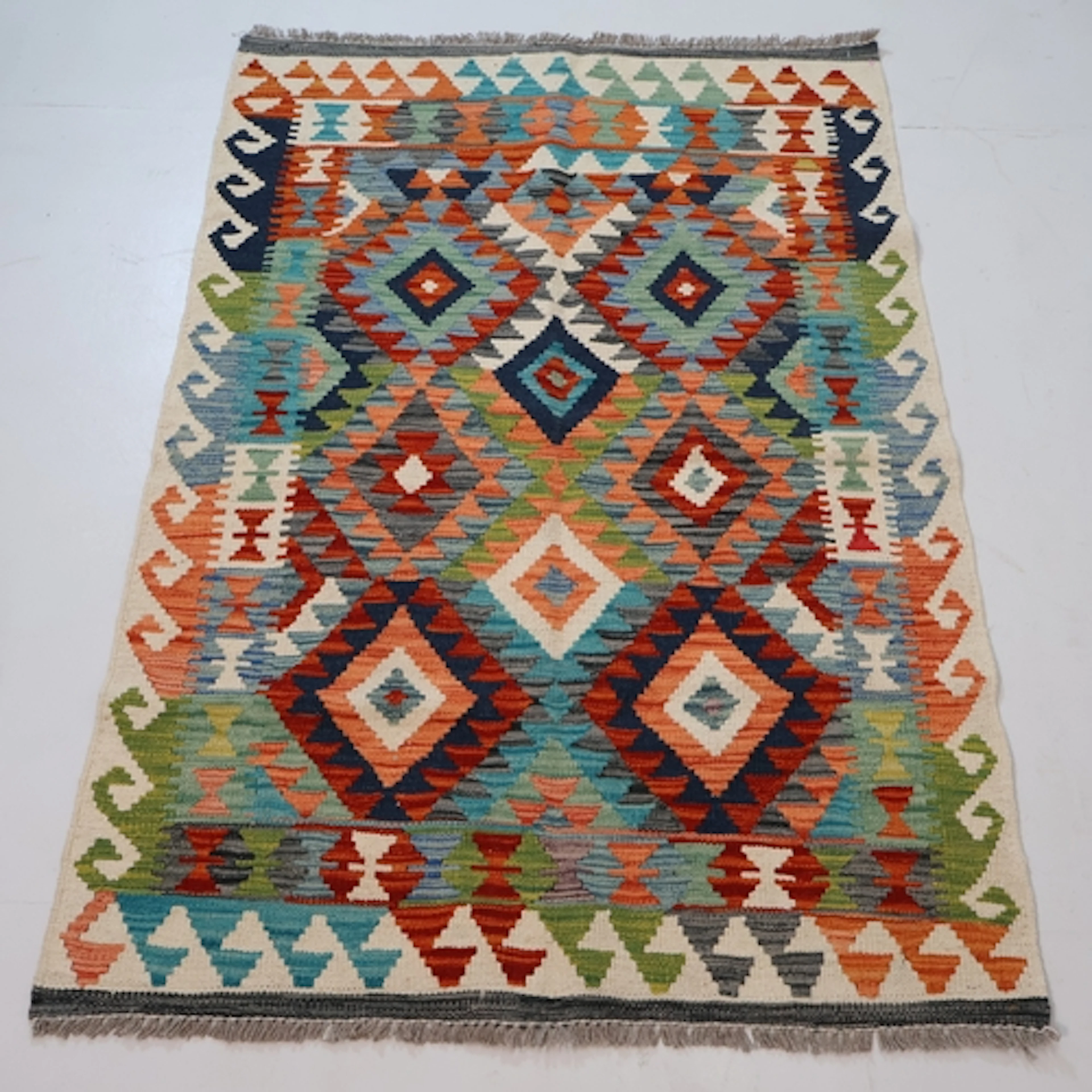 A cream ground multi-coloured geometric design chobi kilim r...