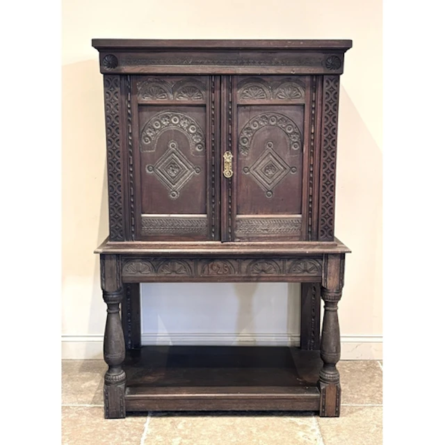A 17th century style carved oak cabinet on stand, the upper ...