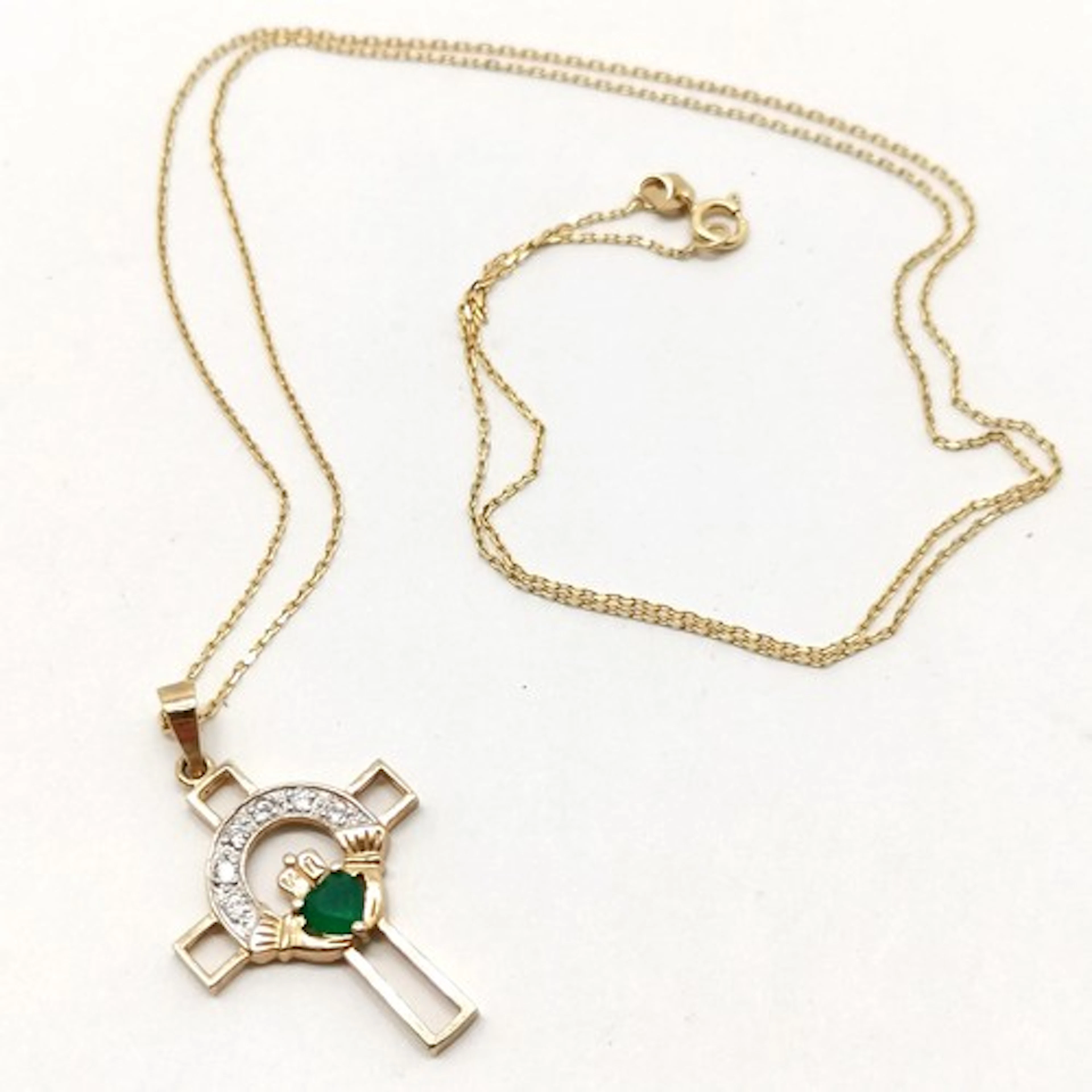 Unmarked gold green & white stone set claddagh cross pendant...