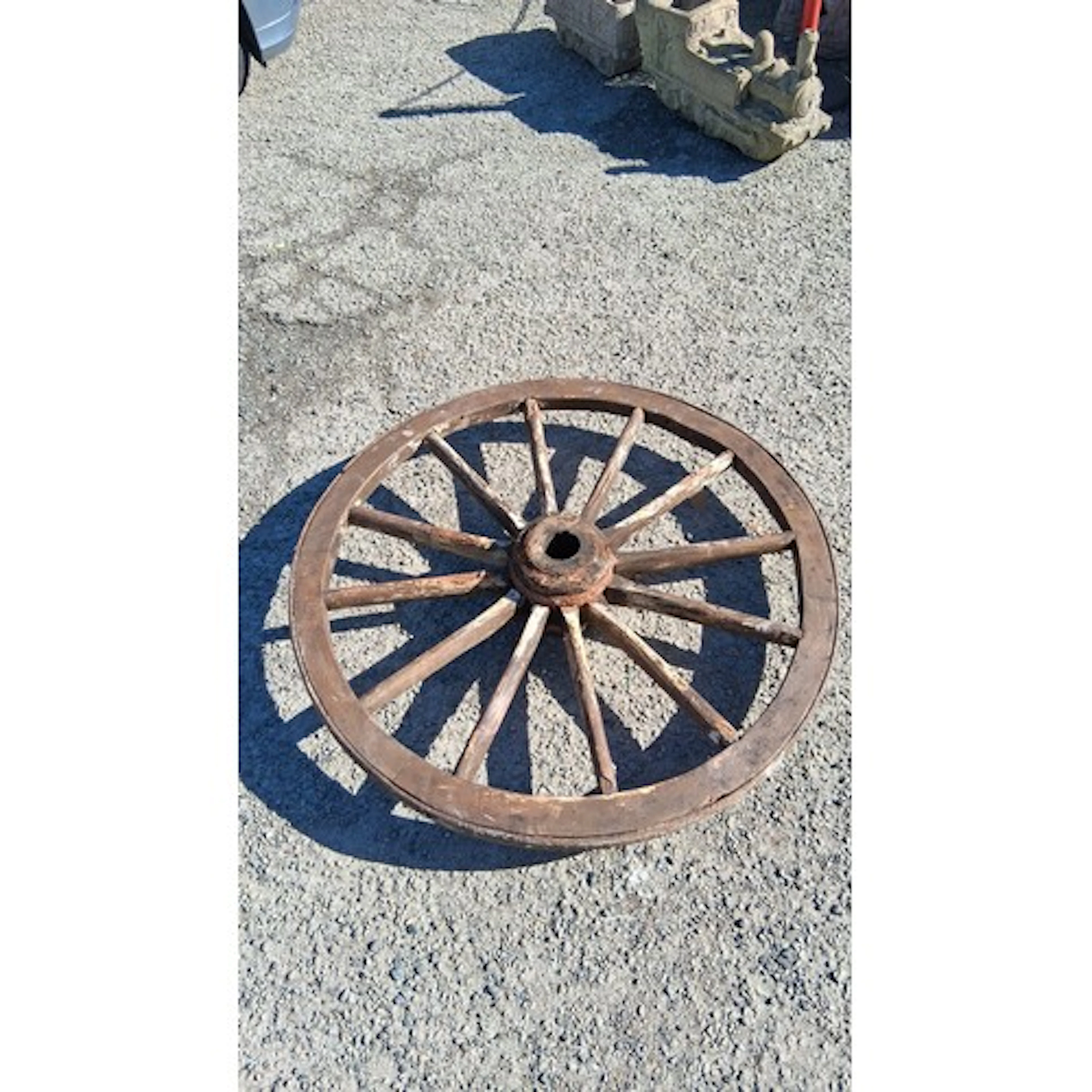 A rustic wooden cart wheel with iron tyre, the hub with iron...