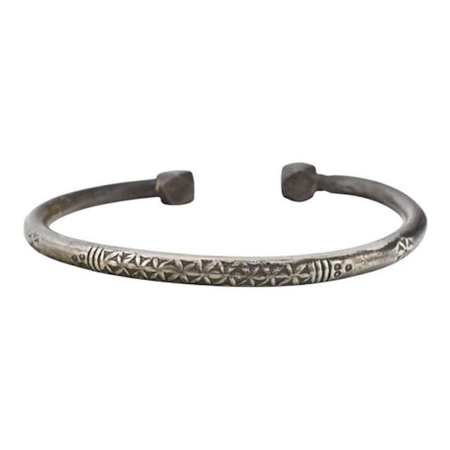 A heavy white metal bangle with geometric block terminals an...