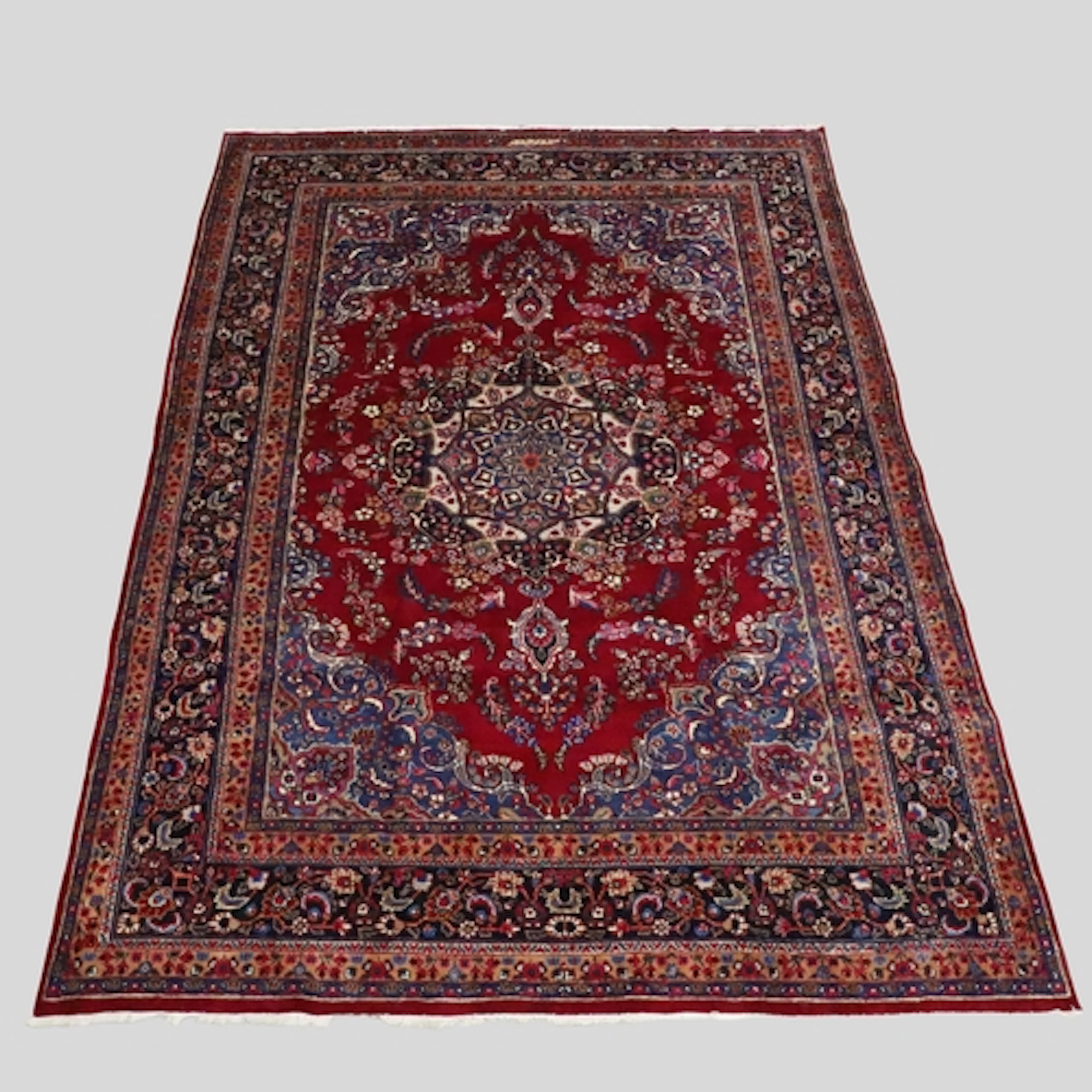 MASHAD CARPET. The deep raspberry field of floral vines arou...