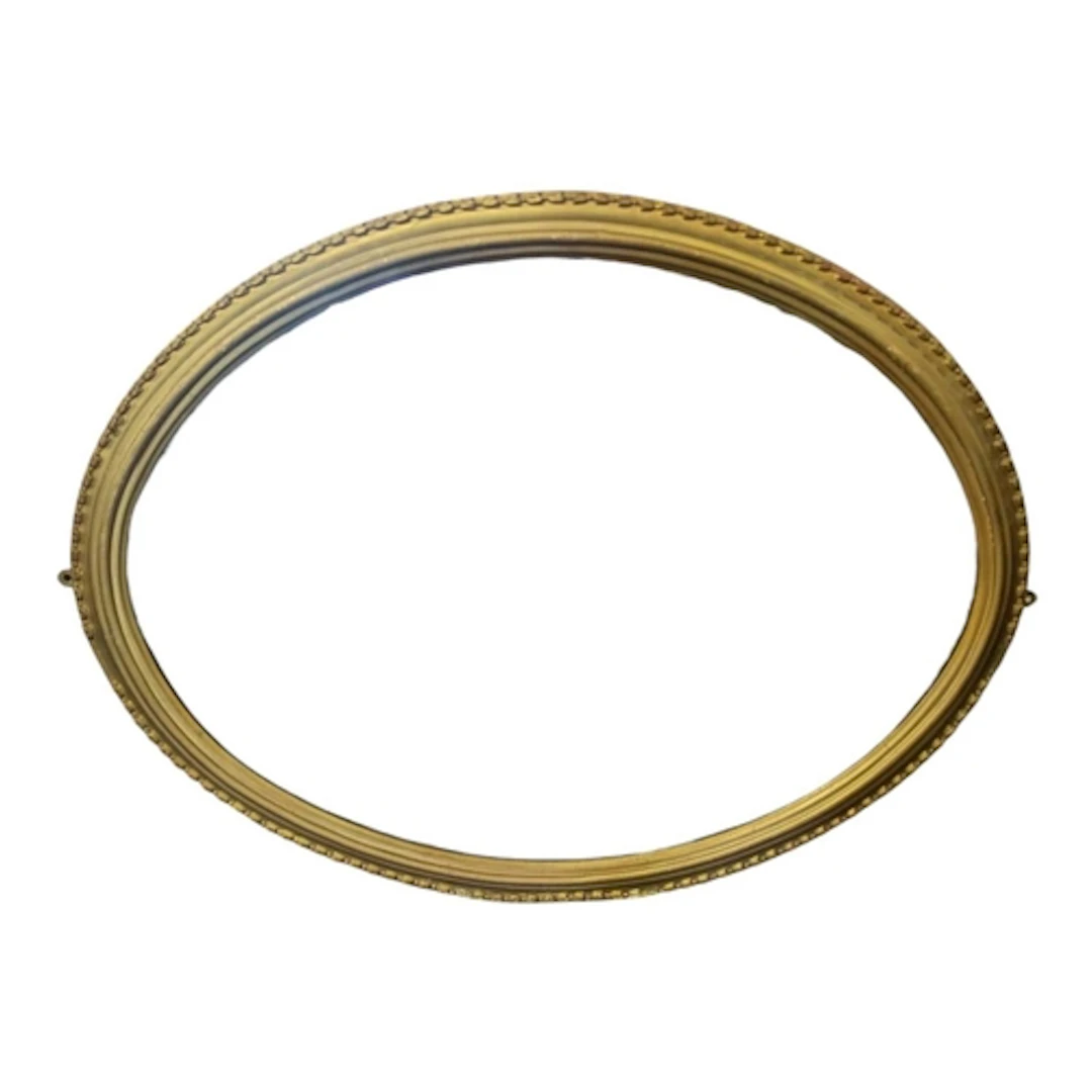 A vintage mid century giltwood oval wall hanging mirror. Gil...