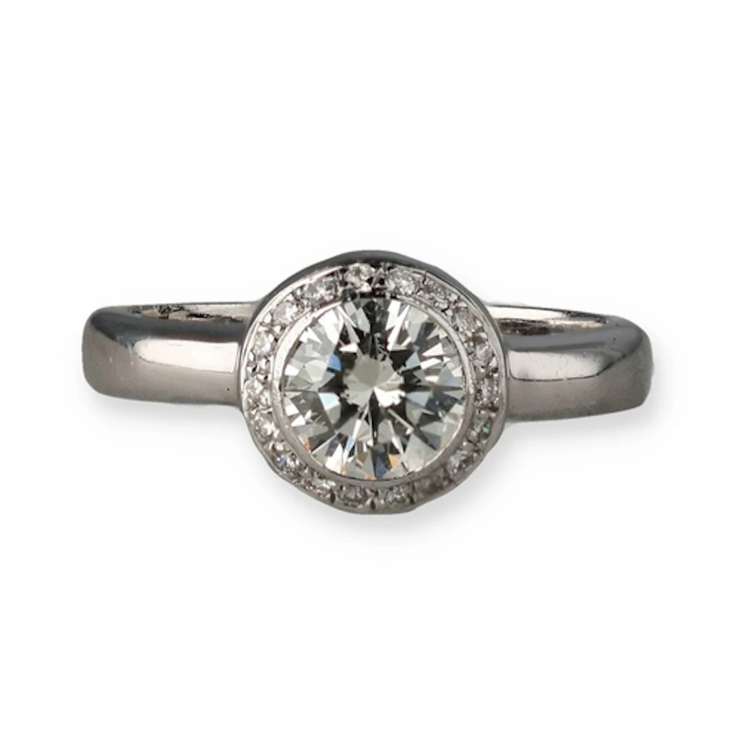 AN 18CT WHITE GOLD AND DIAMOND RING With central diamond sur...