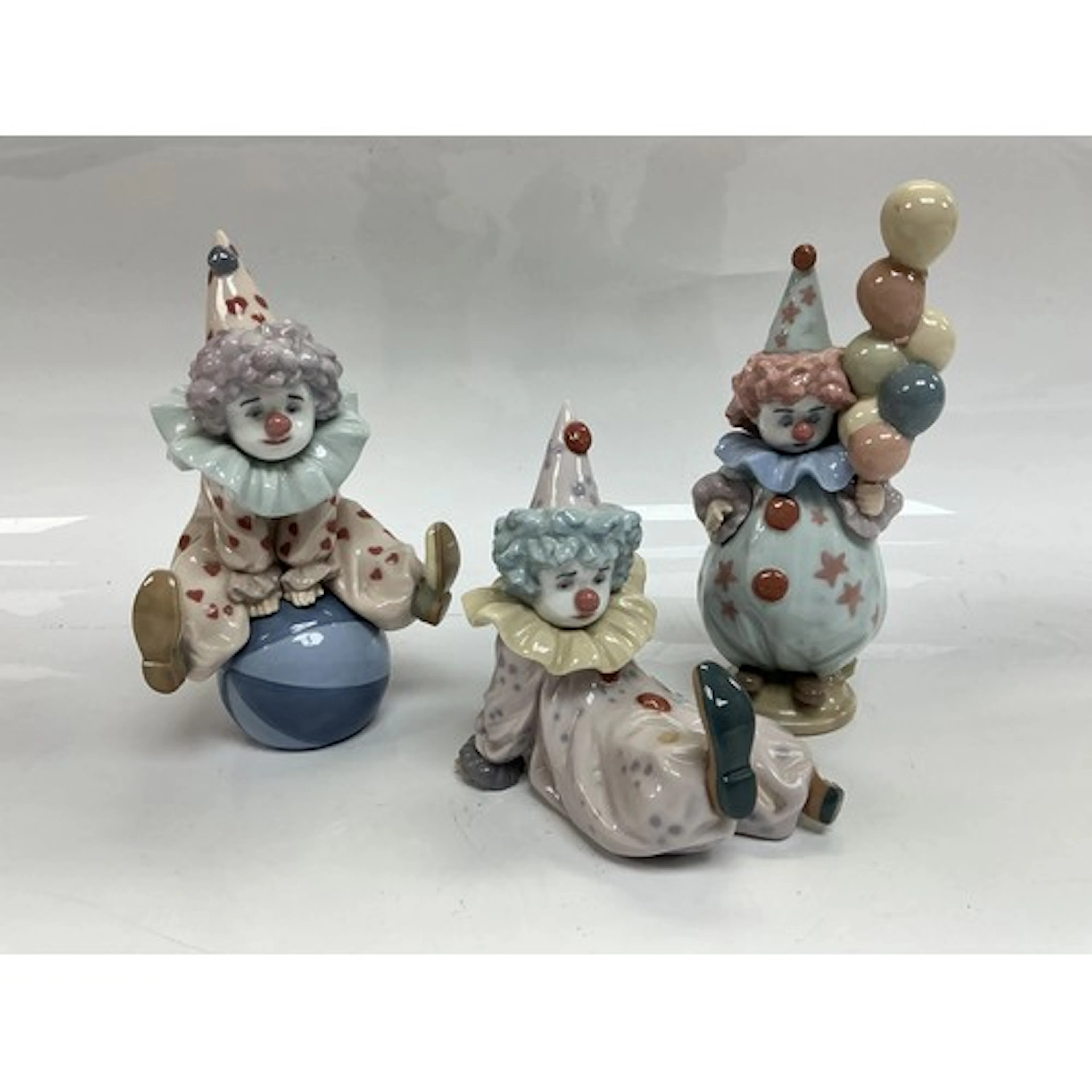 Three Lladro clown figures, tallest approx 18cm.