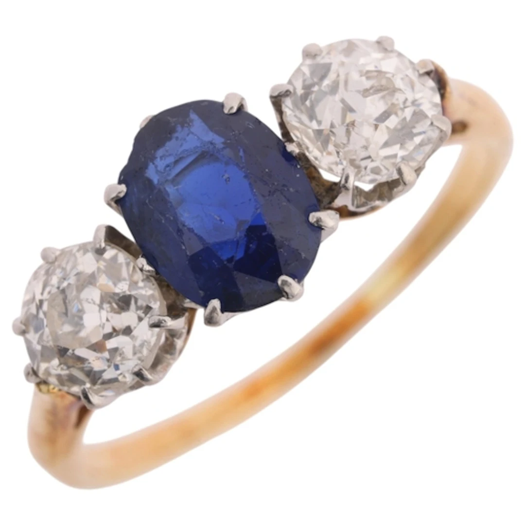 An 18ct gold three stone sapphire and diamond ring, claw set...
