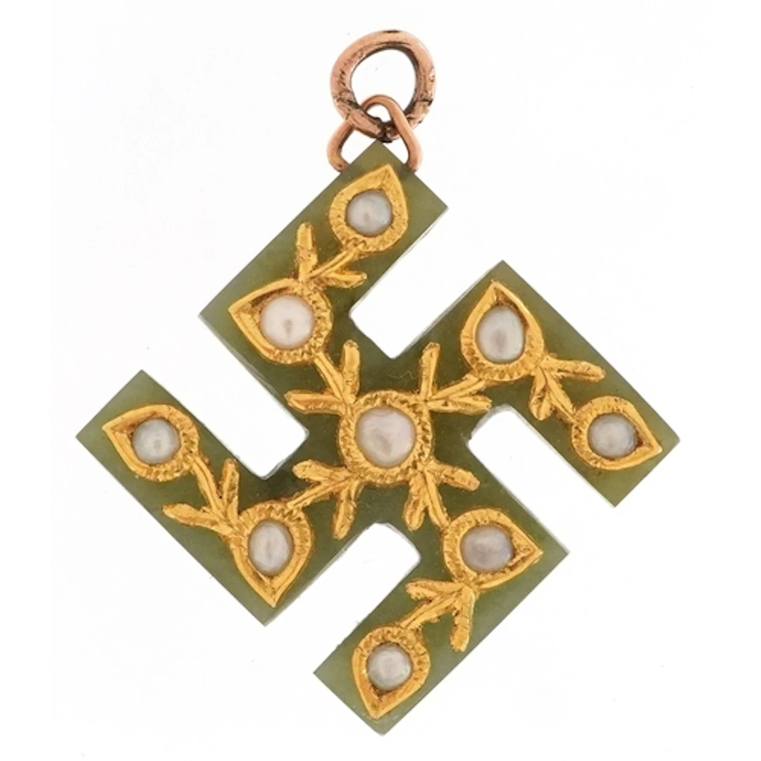 Yellow metal green stone and seed pearl swastika pendant, 2....