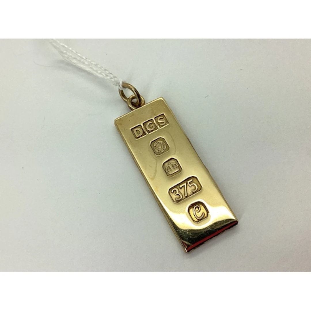 A 9ct Gold 1977 Ingot Pendant, 3.8cm long, textured reverse,...