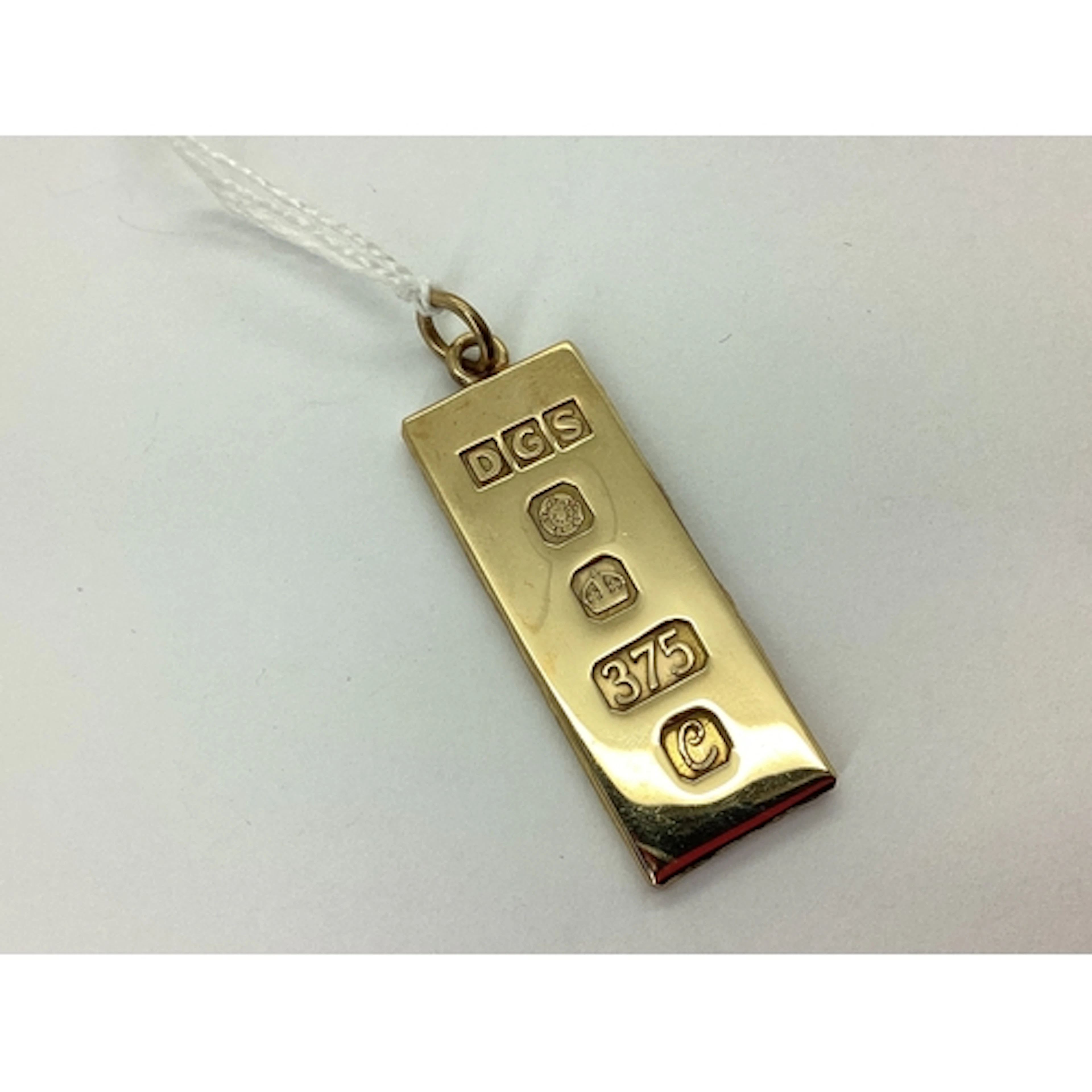 A 9ct Gold 1977 Ingot Pendant, 3.8cm long, textured reverse,...