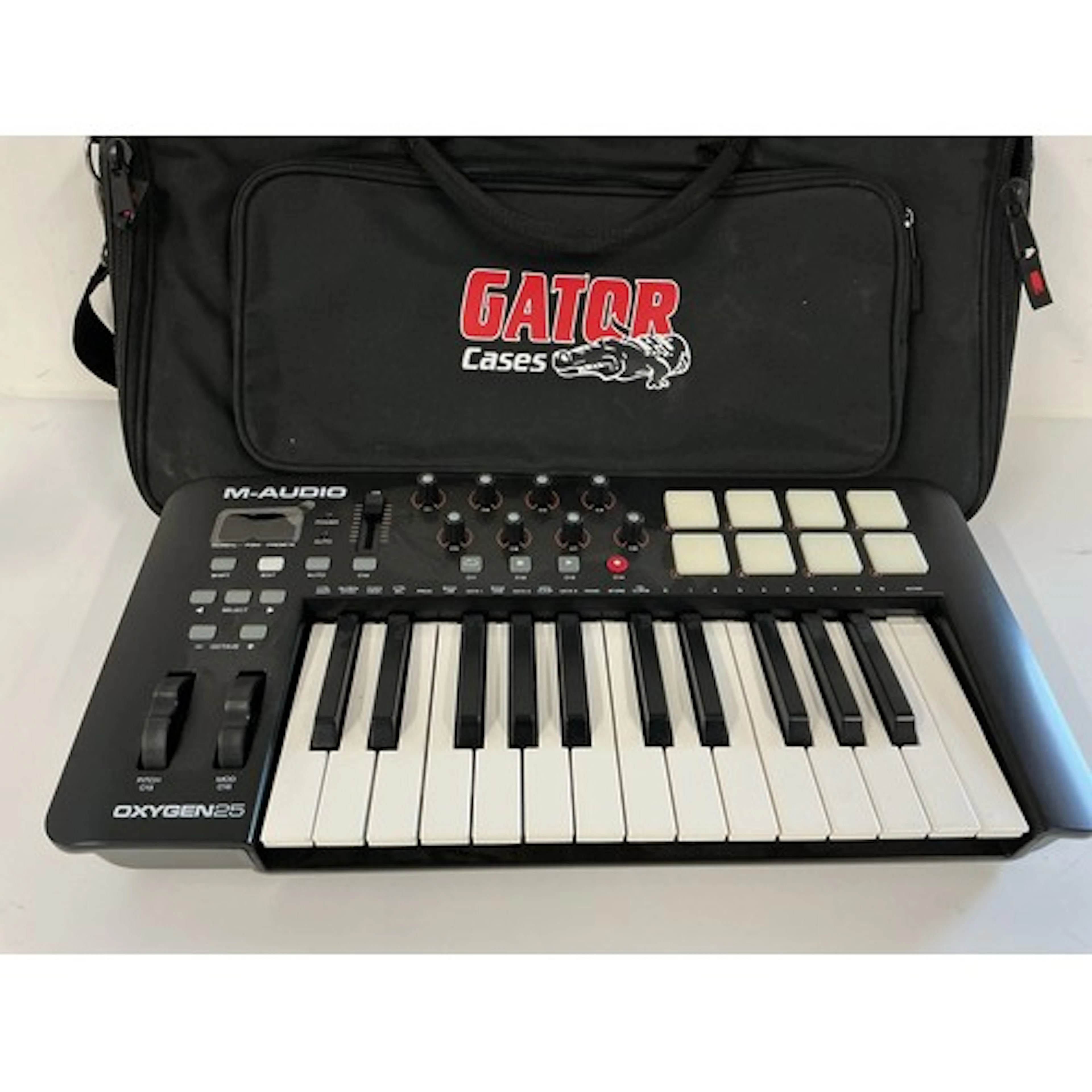 An M-Audio 25 drum machine and a Gator carry case.