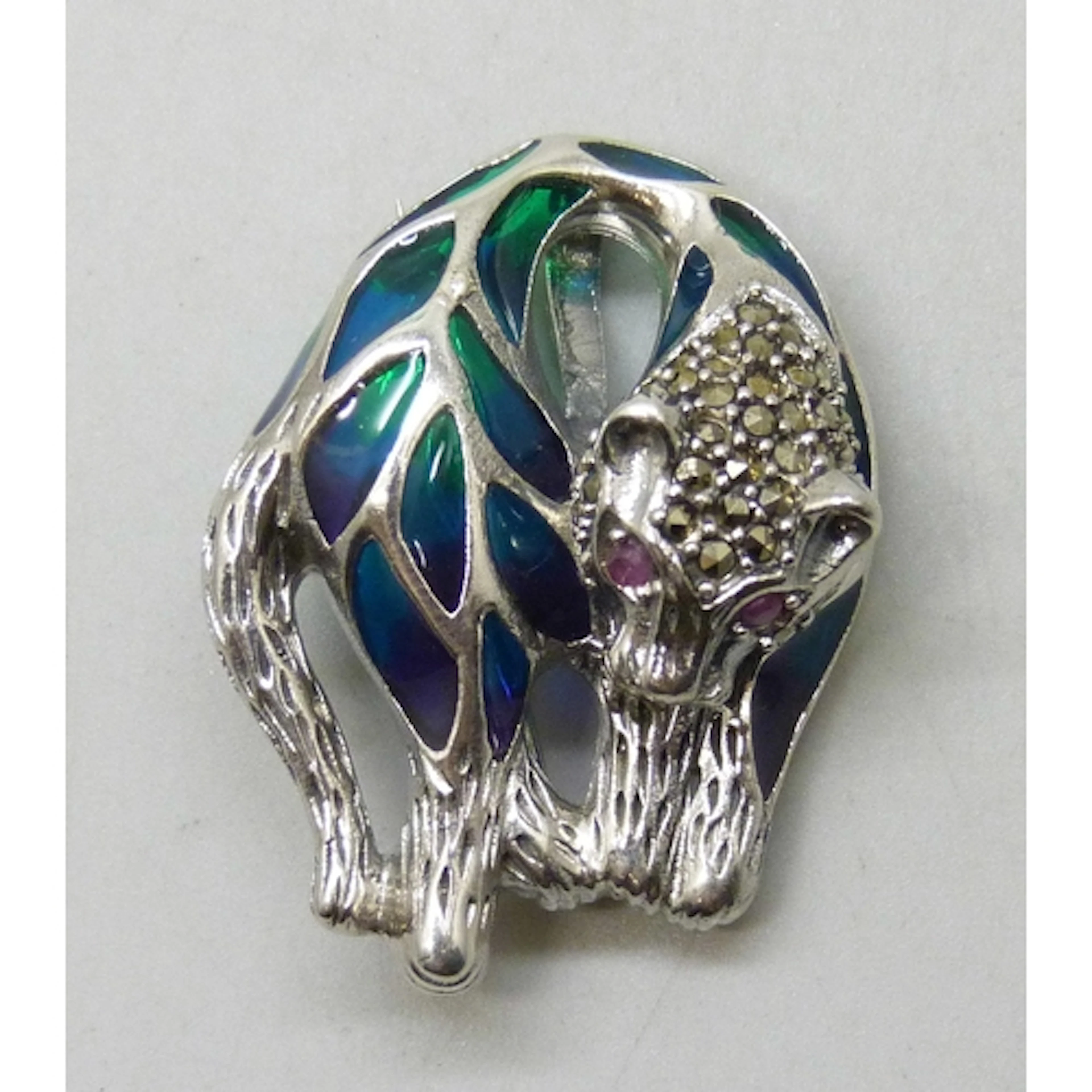 A silver brooch/pendant in the form of a panther set with pl...