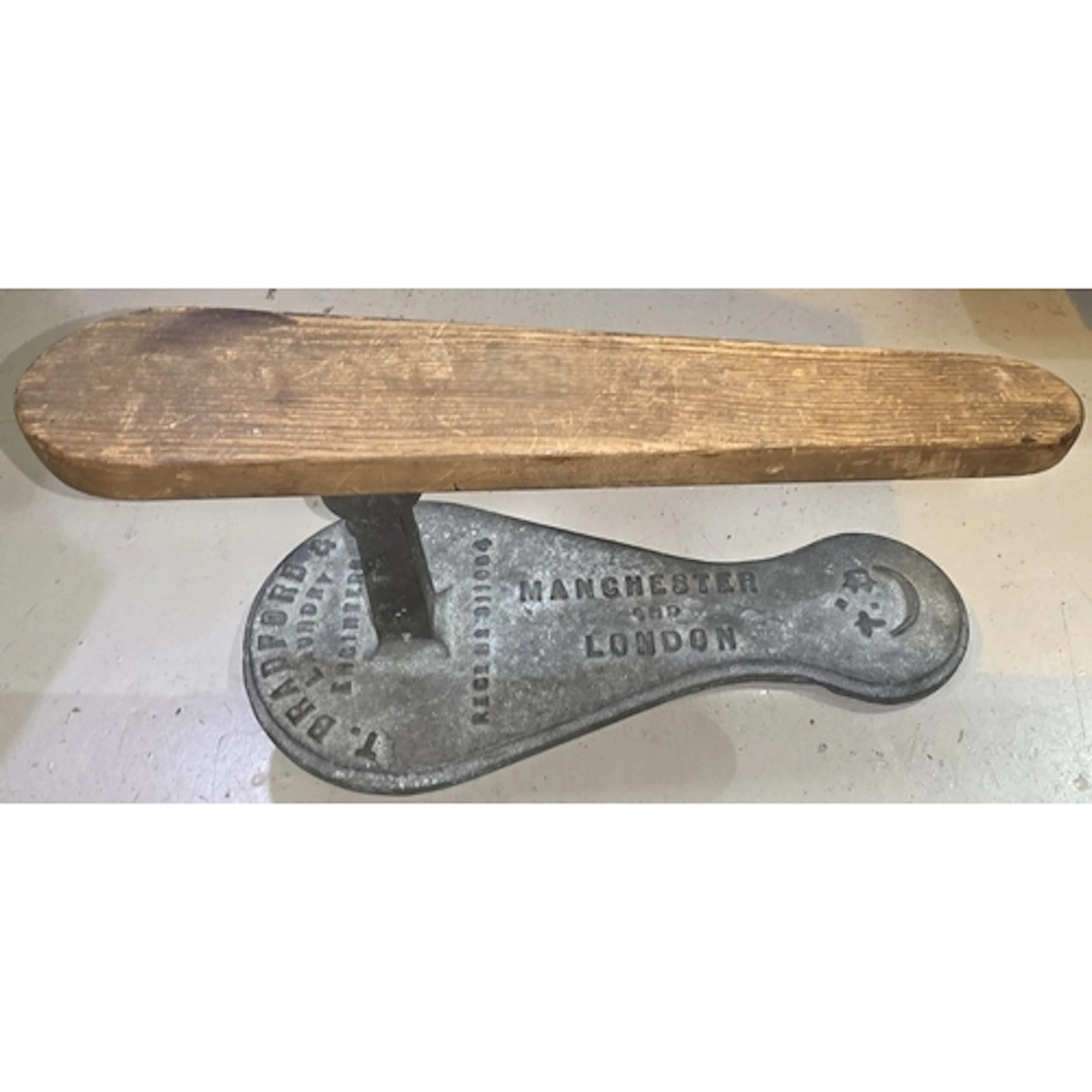 A vintage T. Bradford & Co. cast iron and wood sleeve ir...