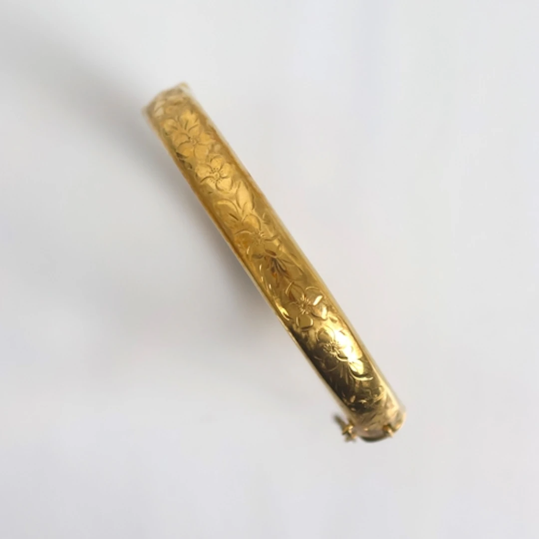 A mid 20th century 9ct gold bangle, the hollow bangle with f...