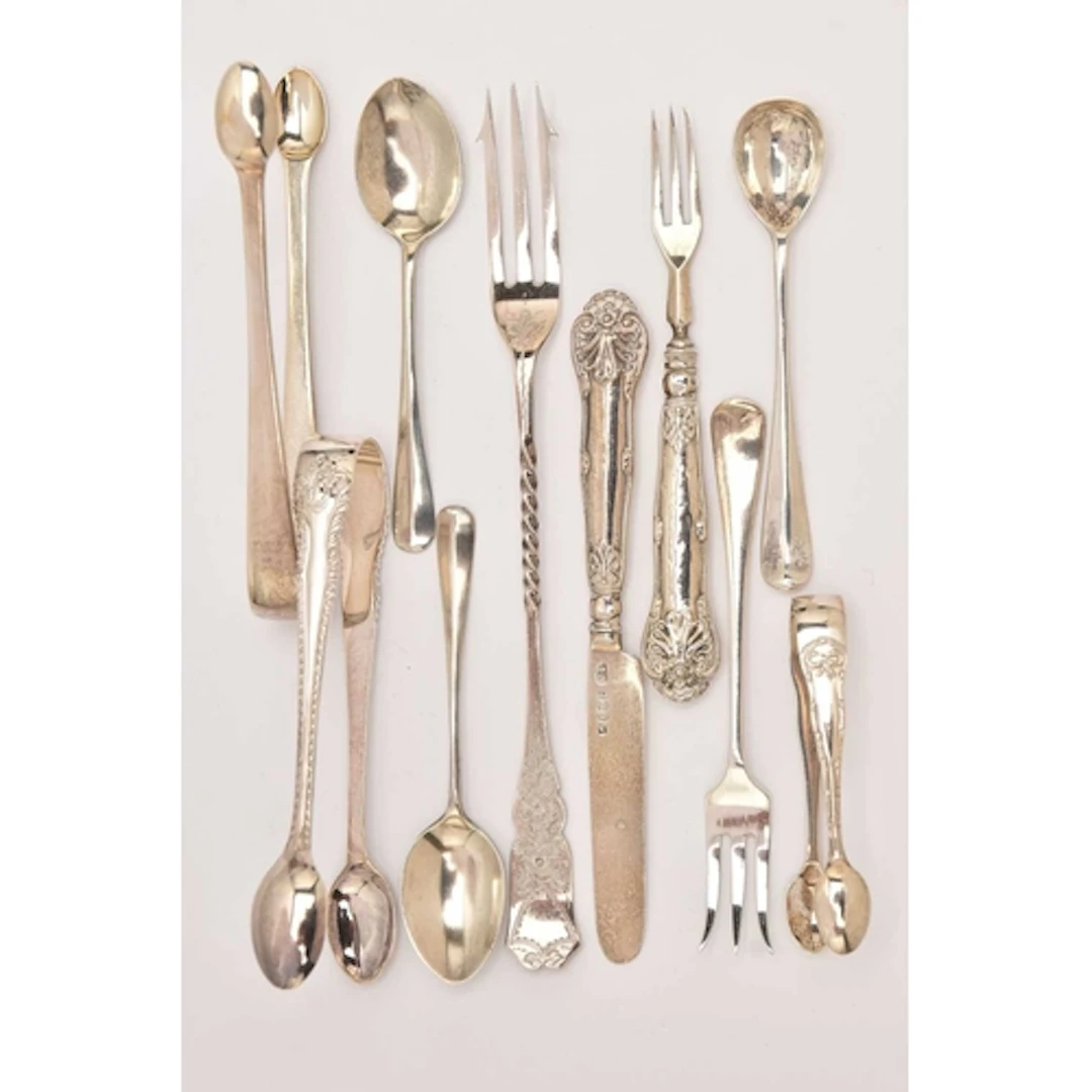 AN ASSORTMENT OF SILVER CUTLERY, to include three pairs of s...