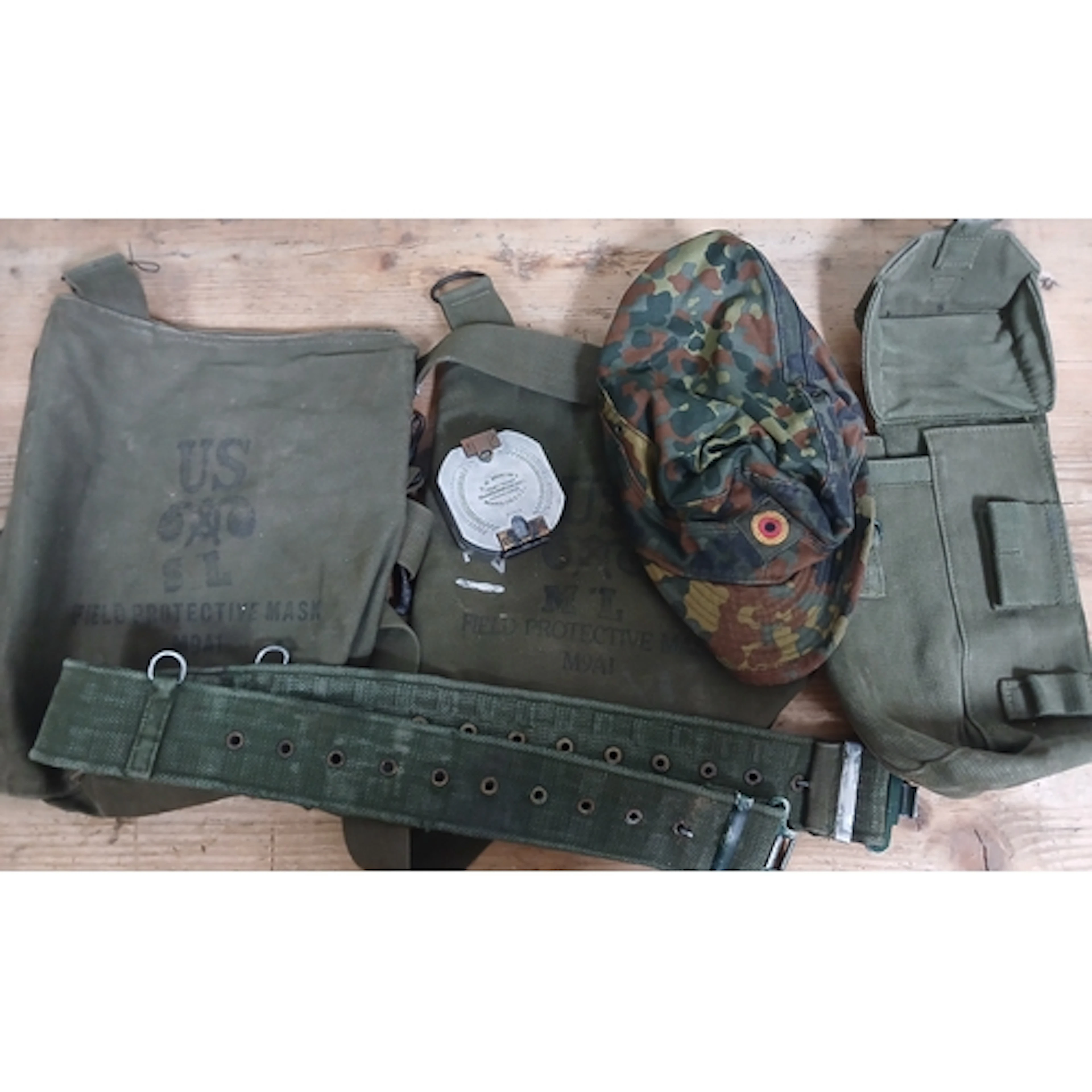 A US Army cap, belt, bags and a Bruntons compass.