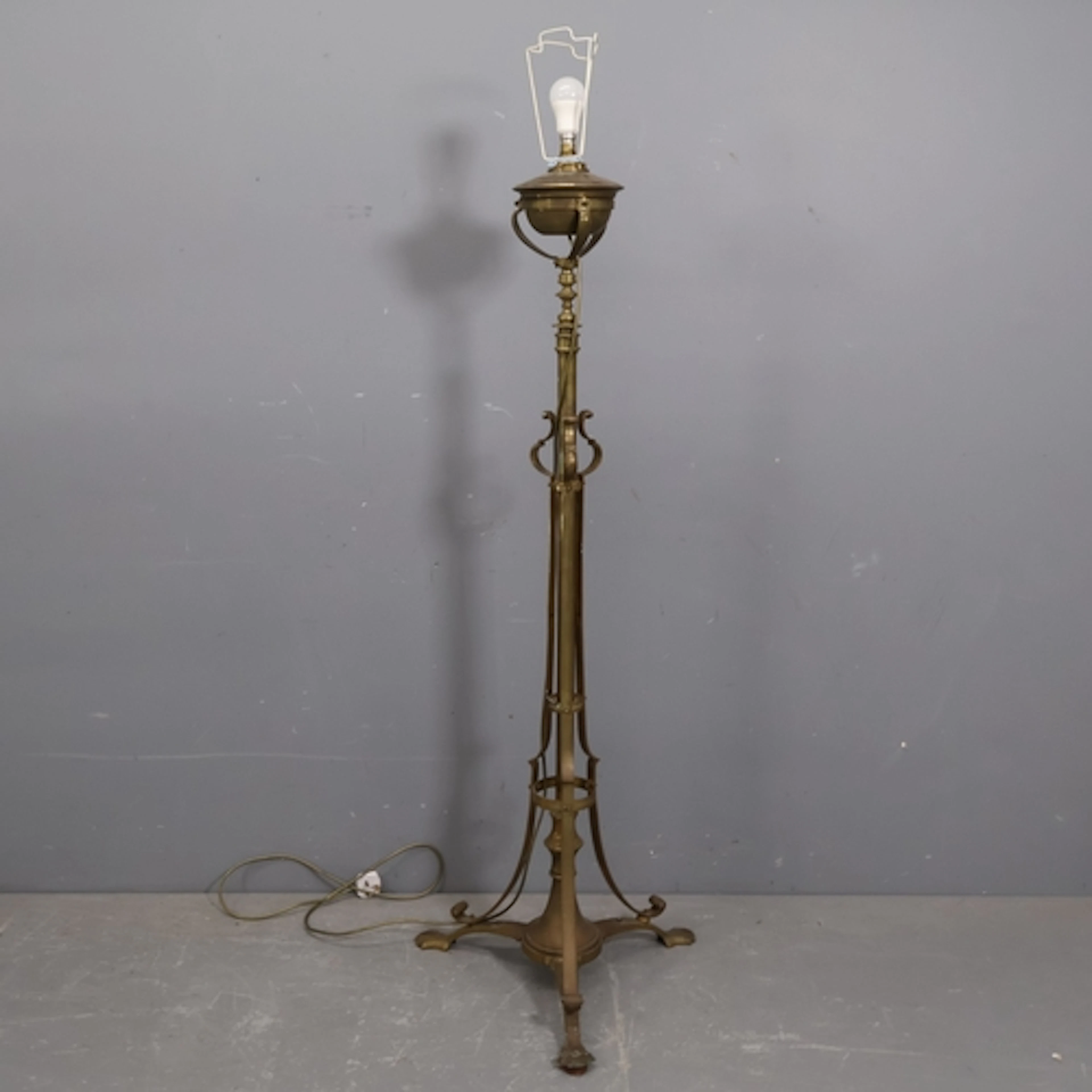 An antique brass floor standing oil lamp, converted to elect...