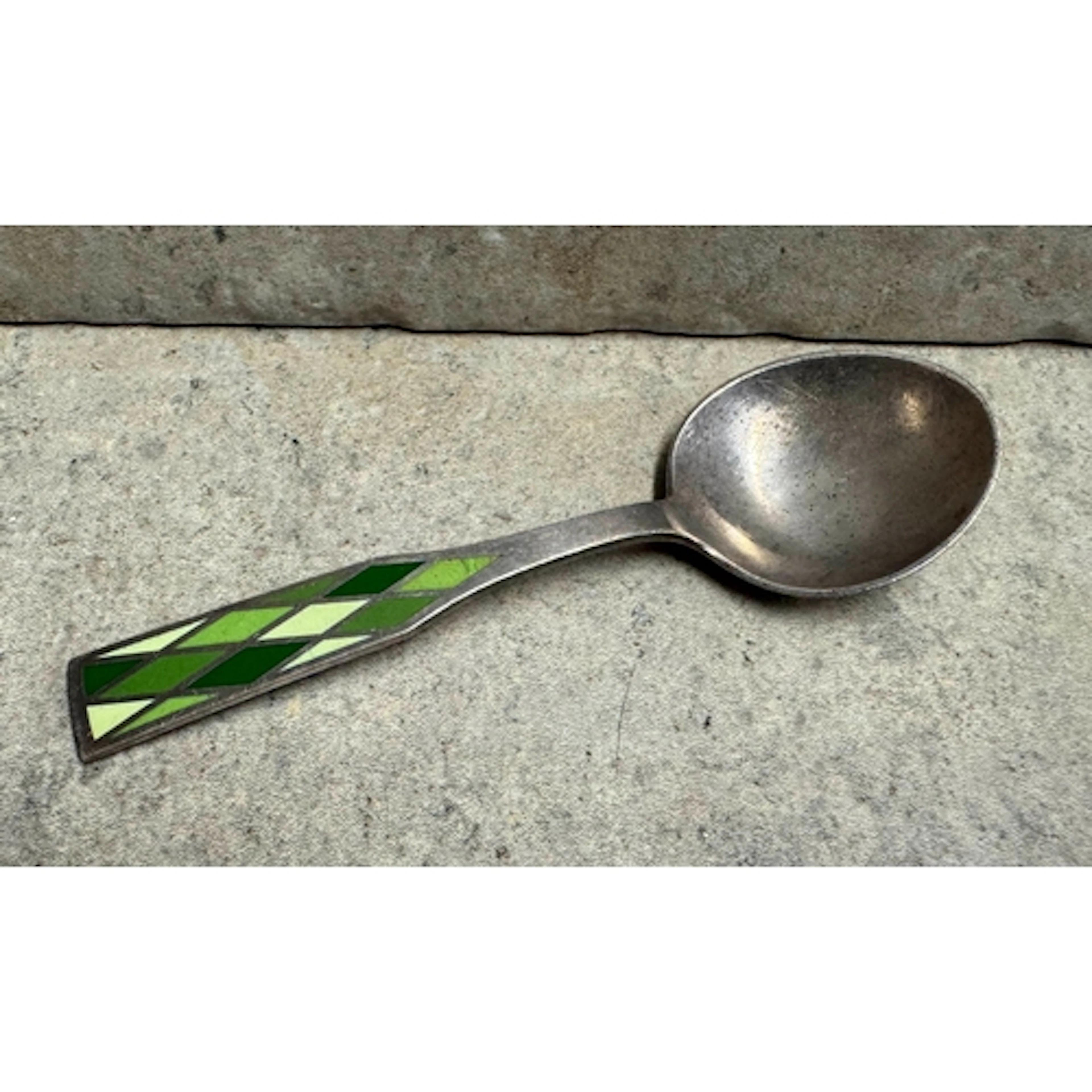 GEORG JENSEN: A silver spoon with green enamel decoration. A...