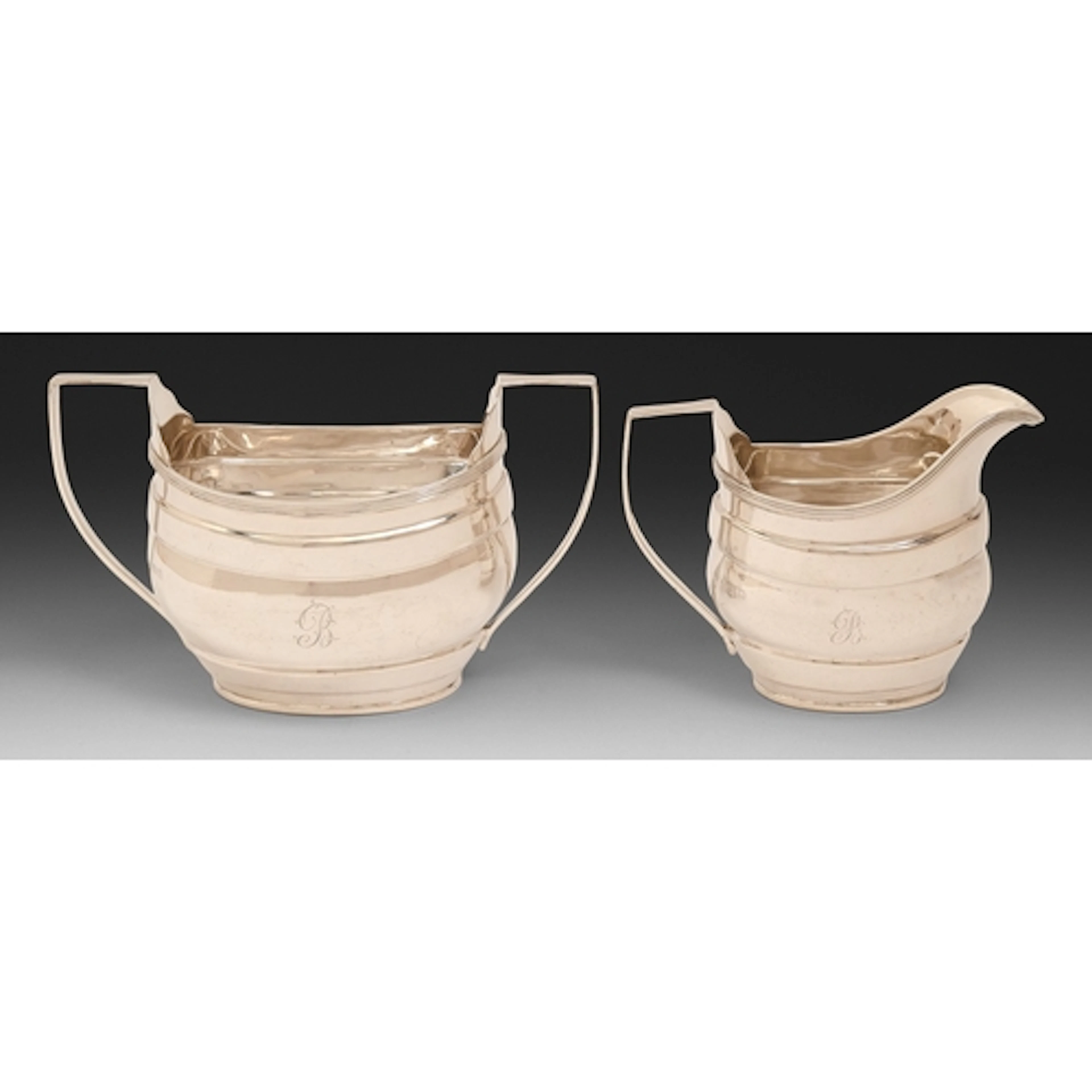 A George V silver cream jug and sugar bowl, of banded design...