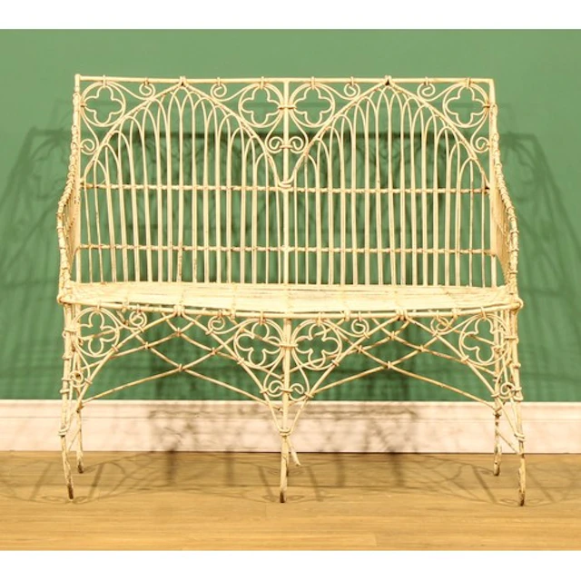 A wrought iron and wirework garden bench, in the Gothic Revi...