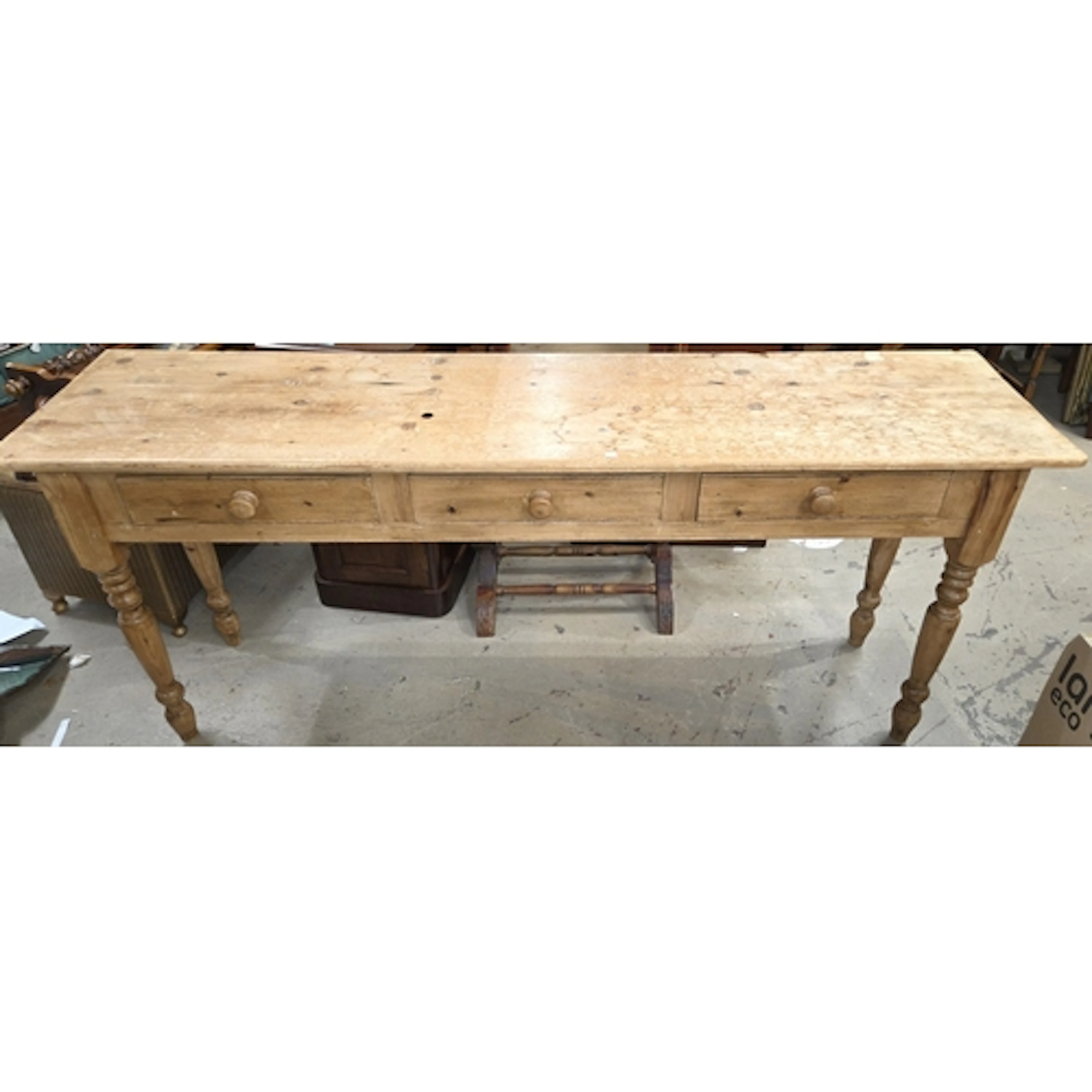 A stripped pine farm house kitchen side table with three dra...