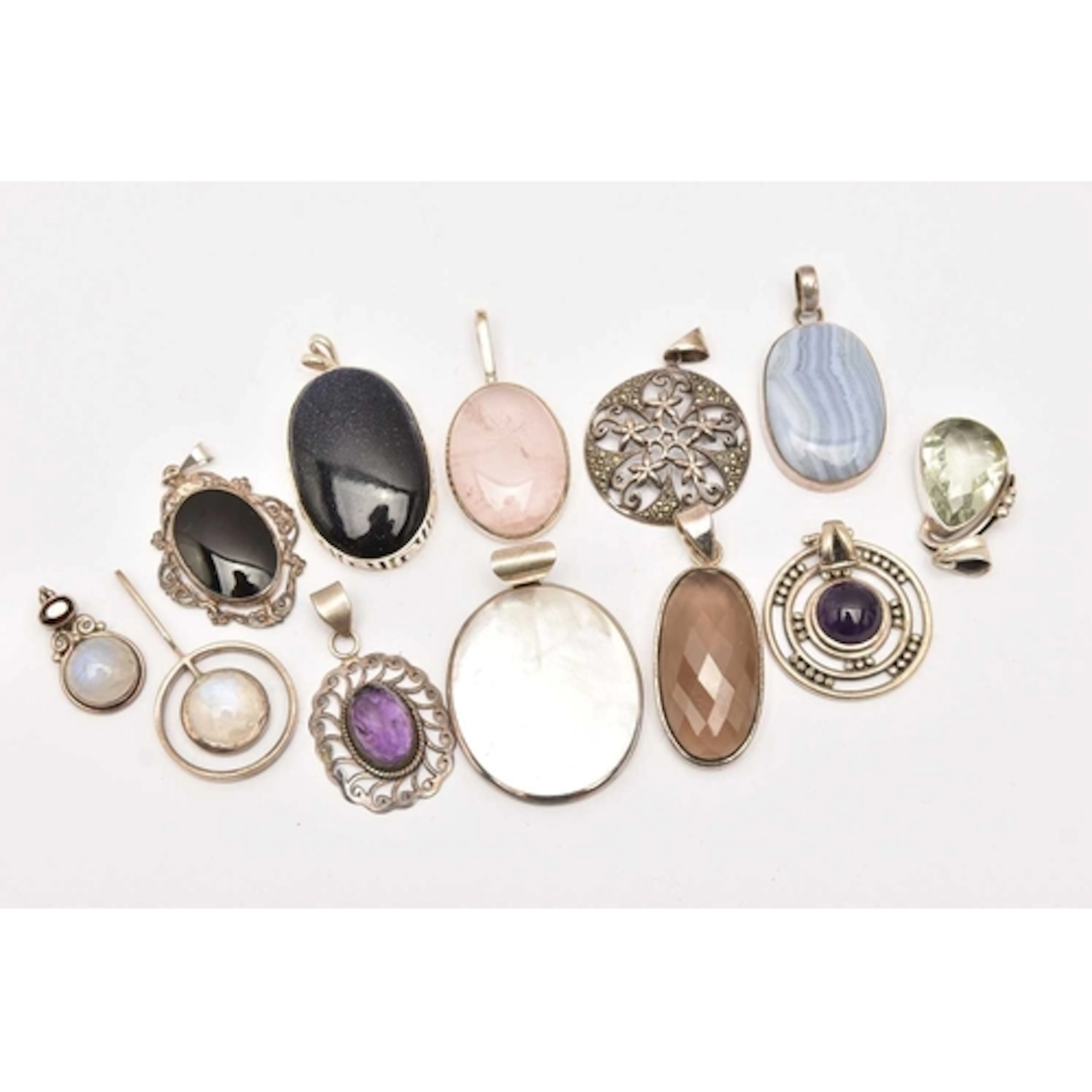 AN ASSORTMENT OF WHITE METAL, SEMI-PRECIOUS STATEMENT PENDAN...