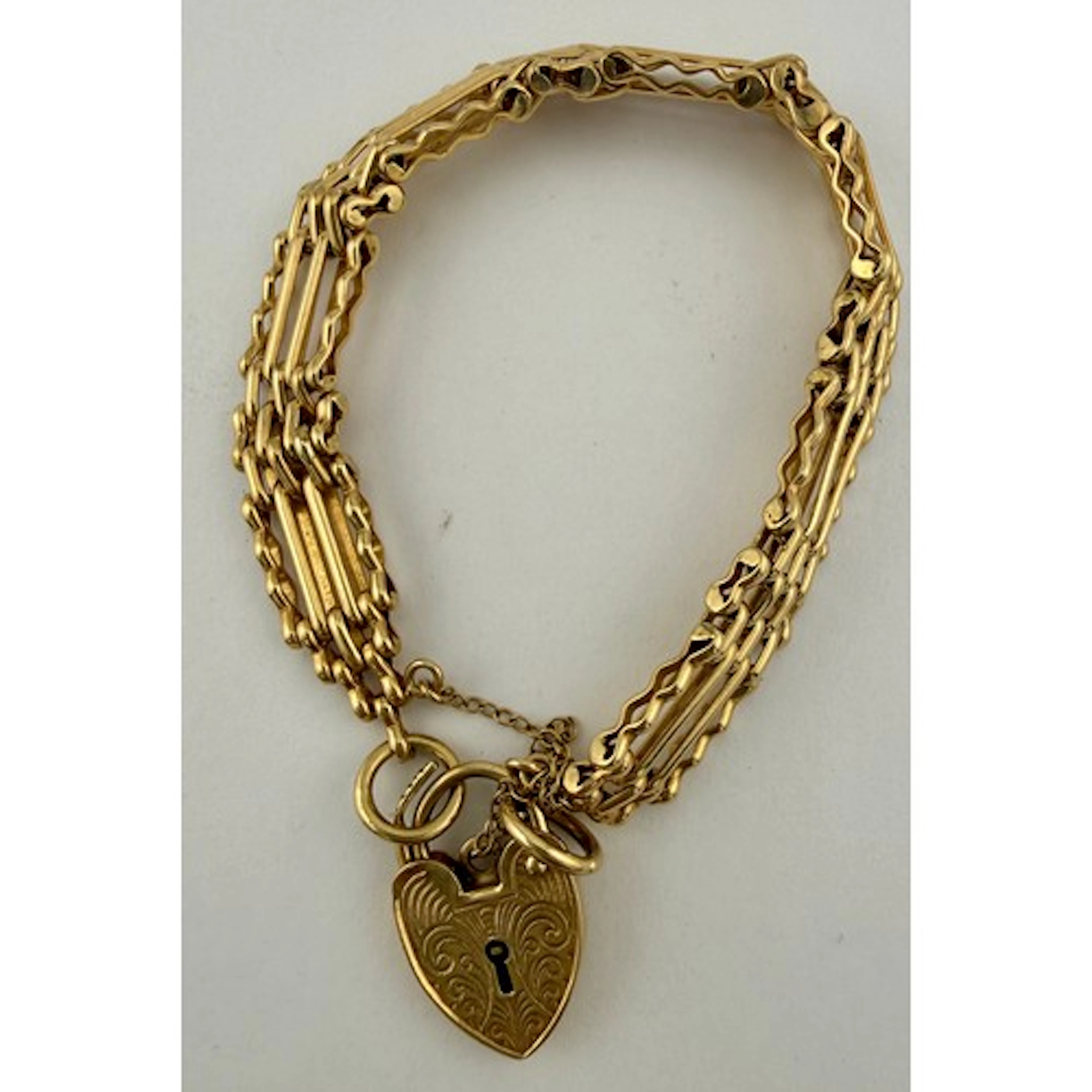 A 9 carat gold gate bracelet with heart shaped padlock. Weig...