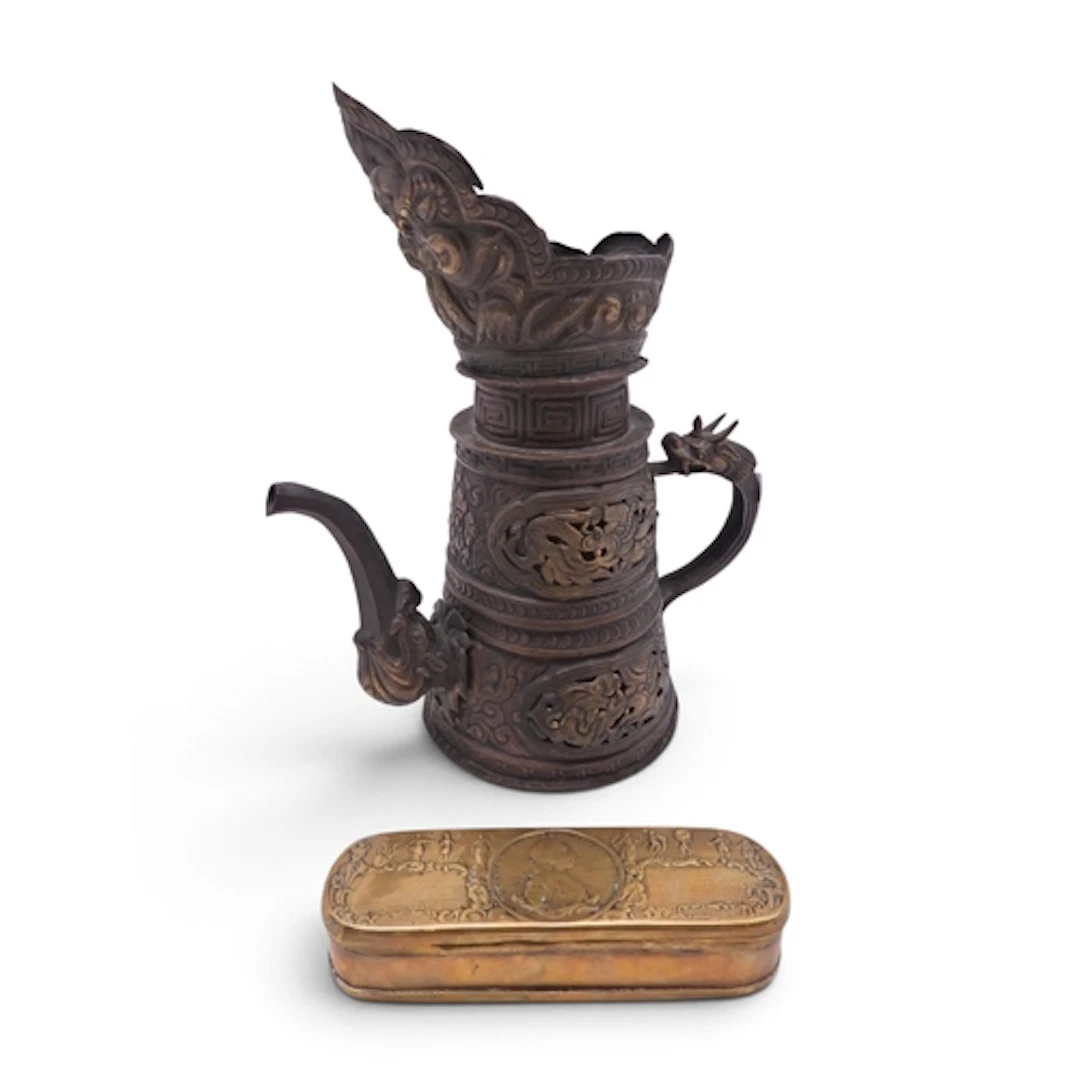 A Tibetan copper ewer cast with panels of grotesques and clo...