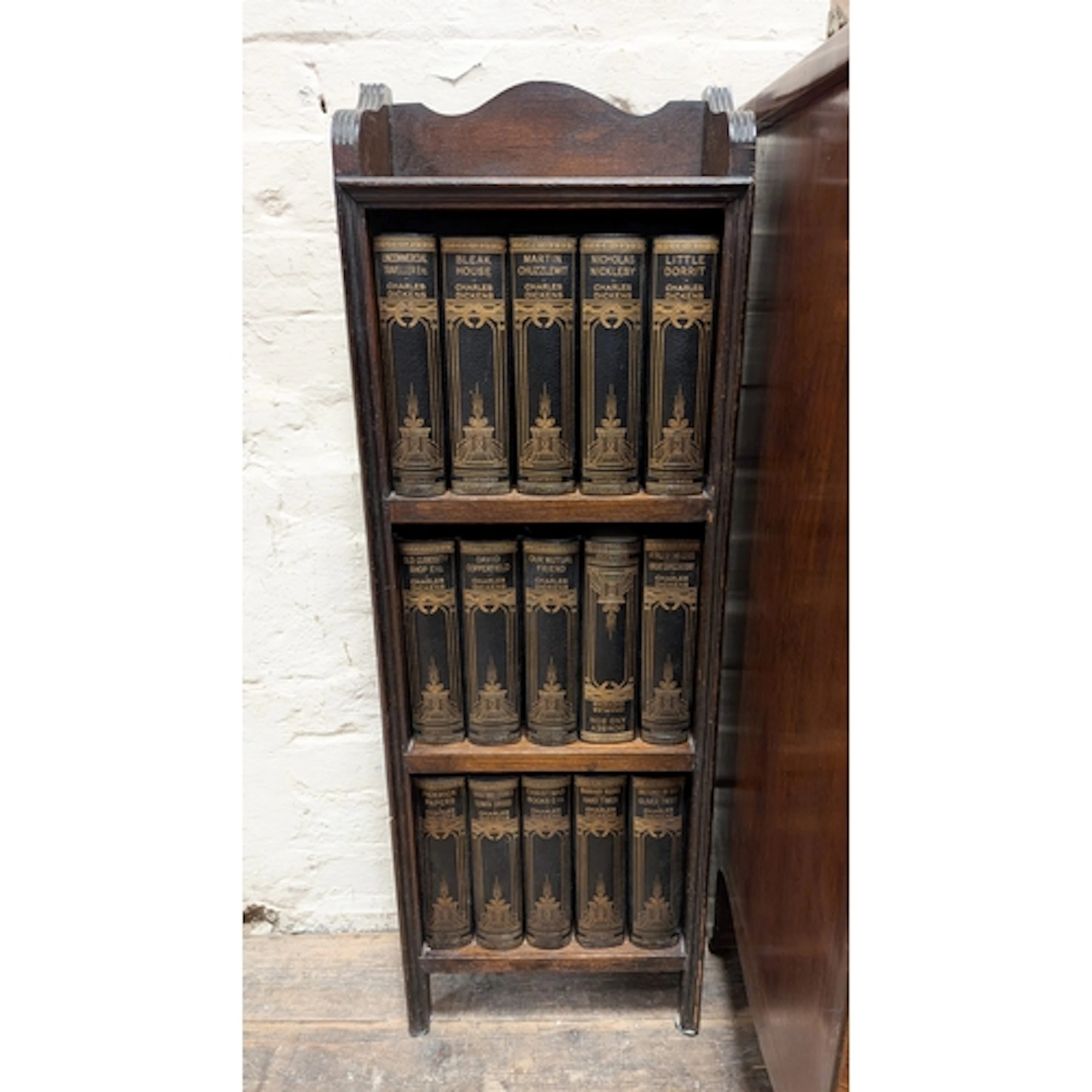 A small 1920's oak bookcase containing a complete set of Cha...
