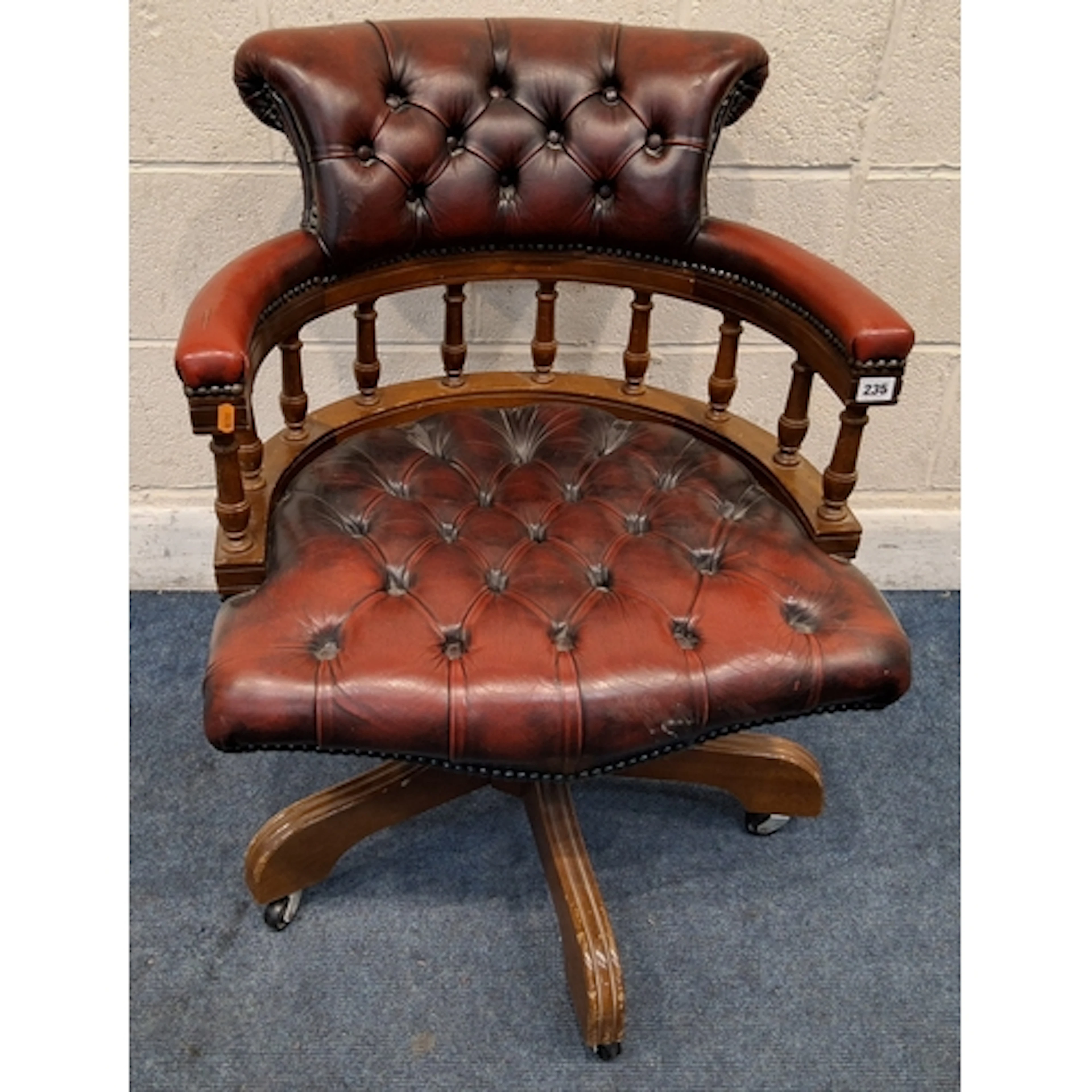 AN OXBLOOD LEATHER SWIVEL OFFICE / CAPTAINS CHAIR, with spin...