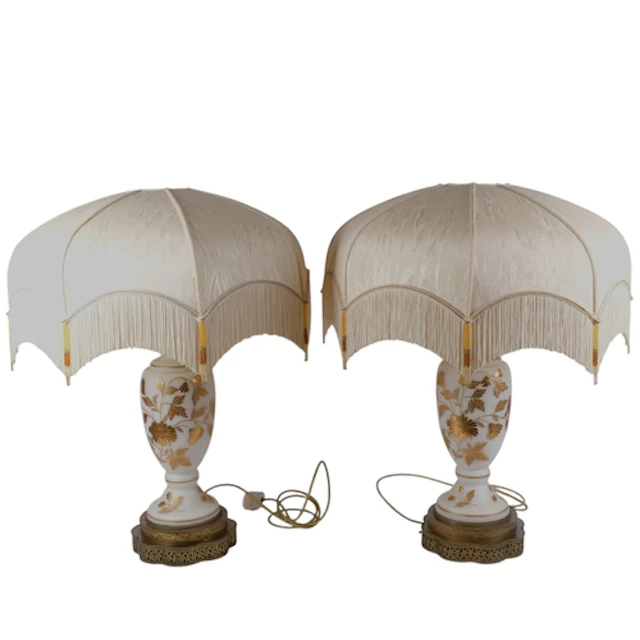 A pair of impressive gilded milk glass table lamps, with fol...