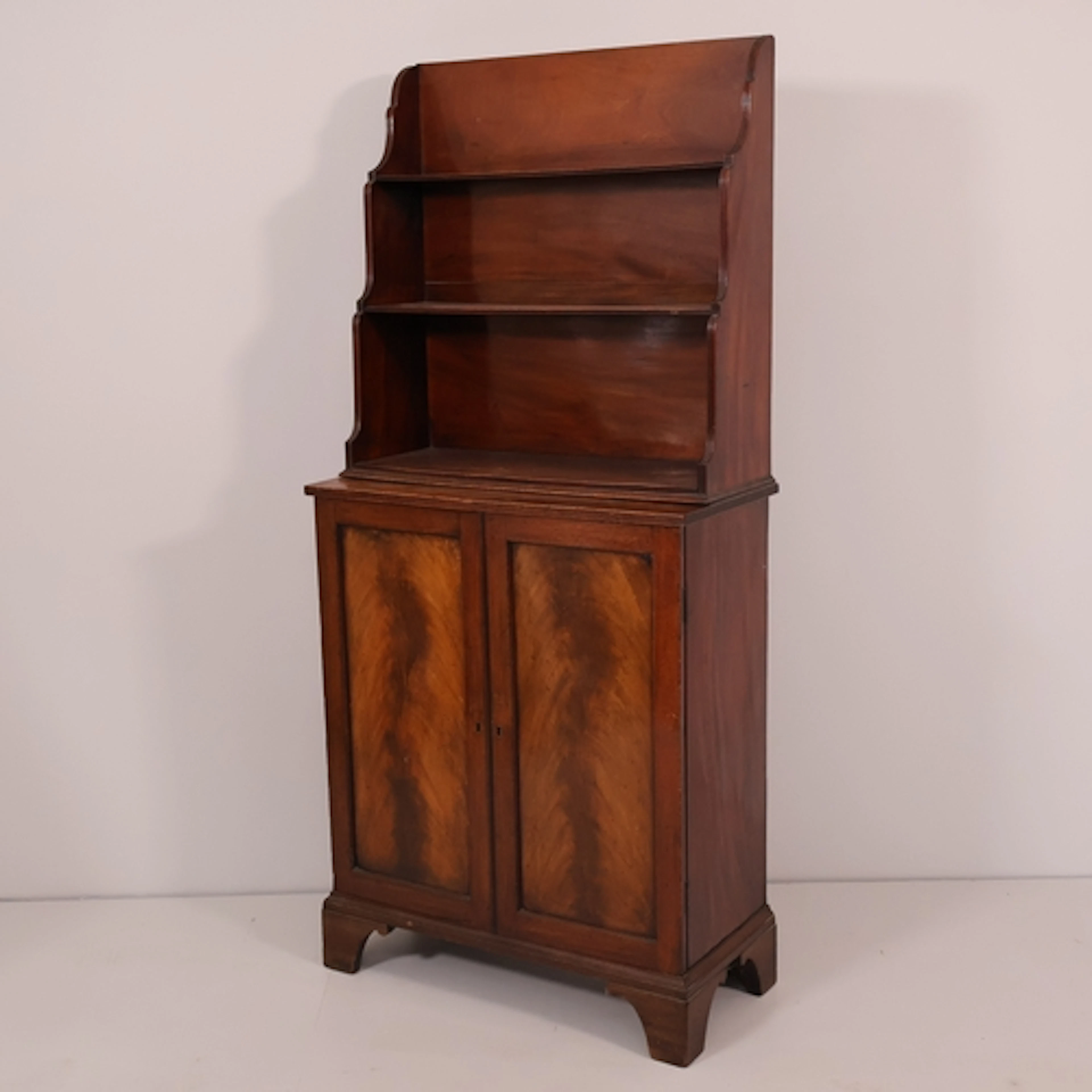 A George IV mahogany bookcase, the open-waterfall top above ...