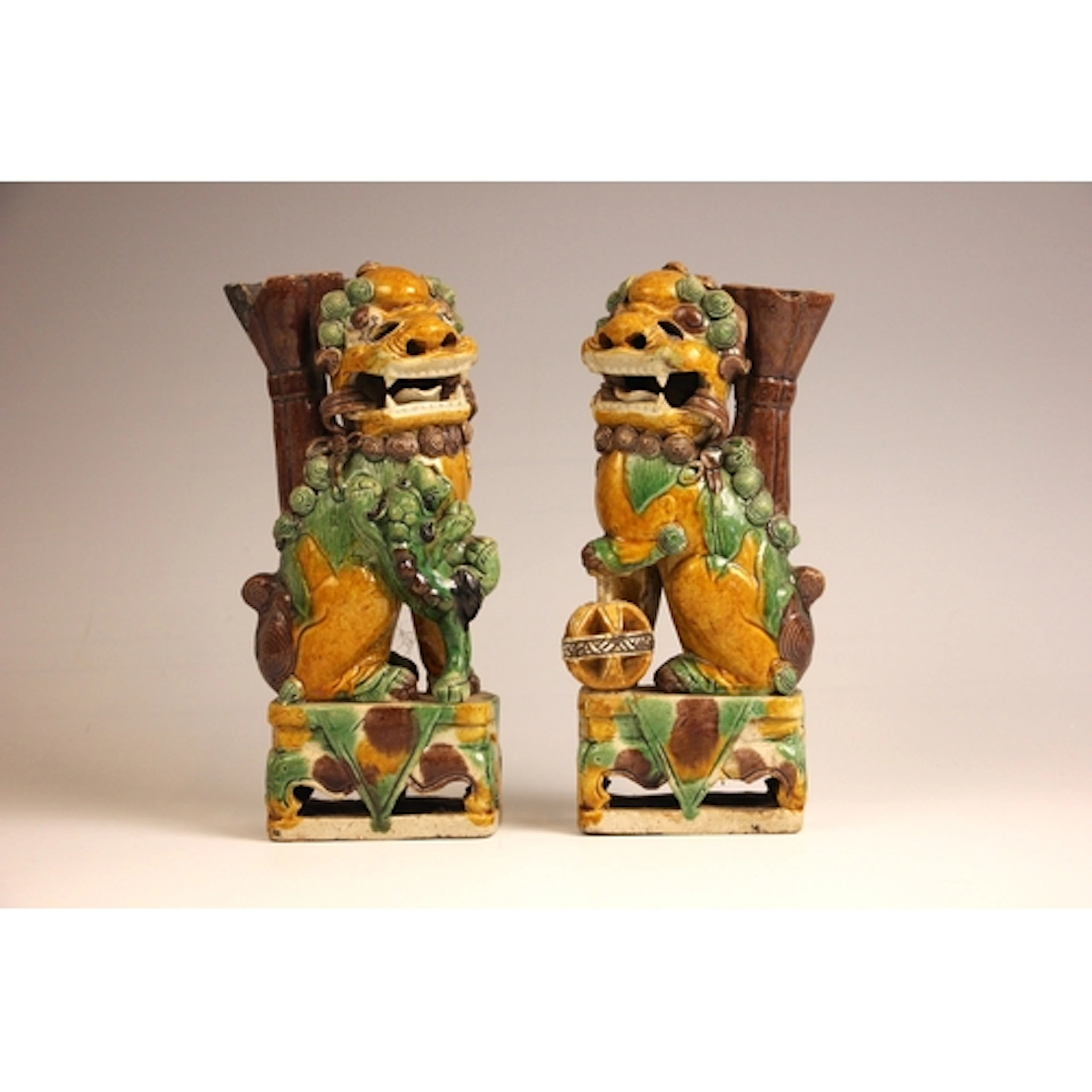 A pair of Chinese Sancai glazed dogs of Fo, one modelled wit...