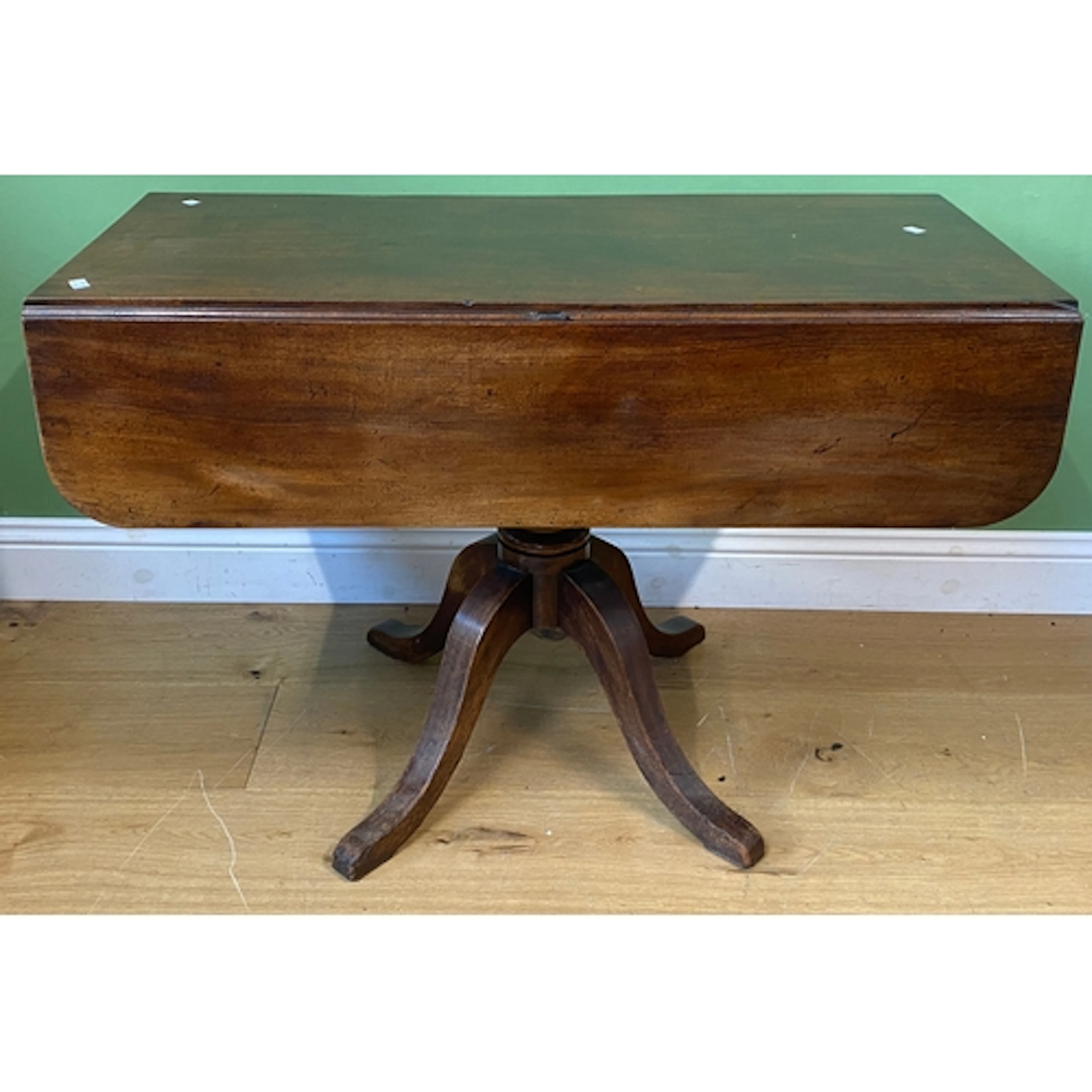 An early 19th century mahogany drop leaf table on turned col...