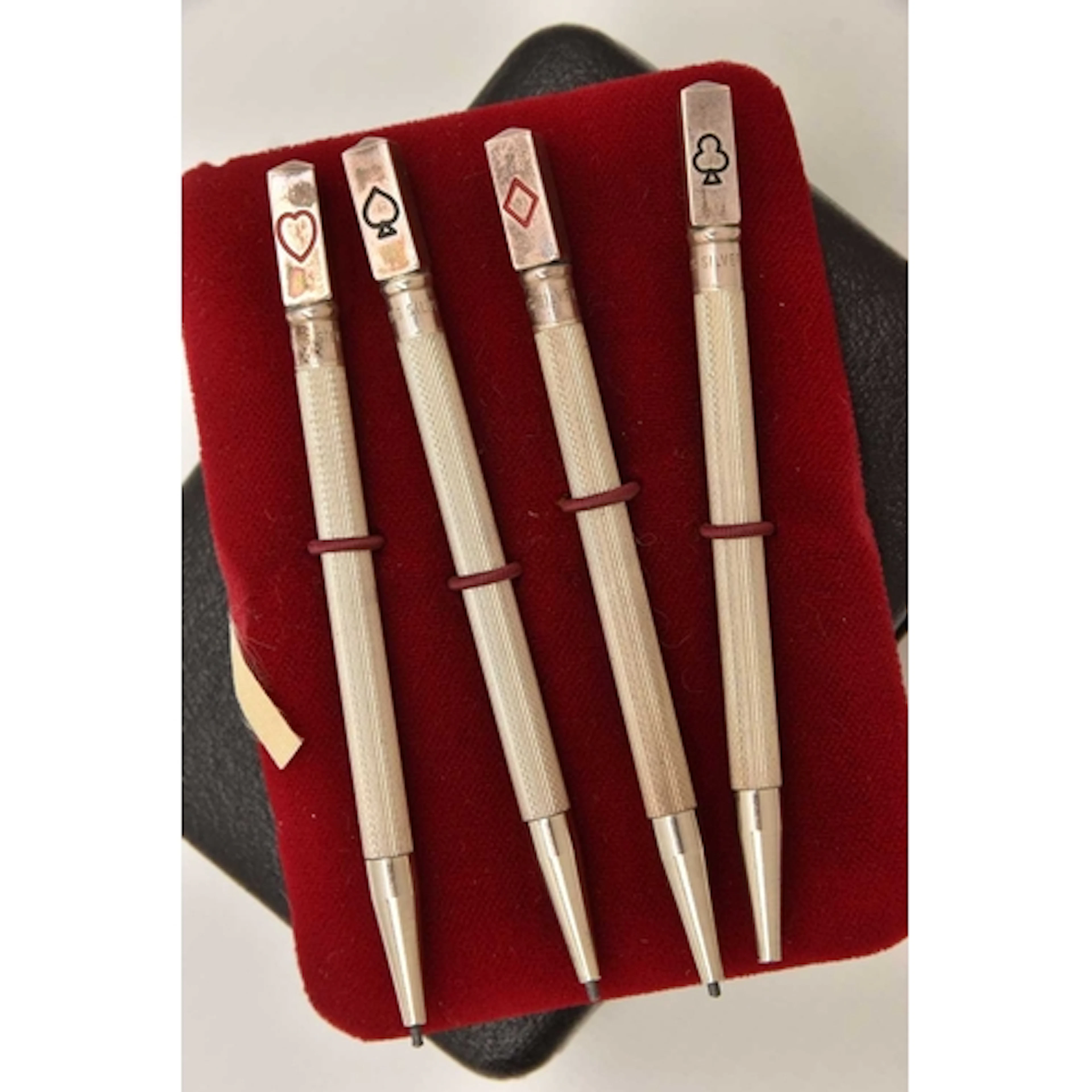 A CASED SET OF FOUR WHITE METAL BRIDGE PENCILS, each stamped...