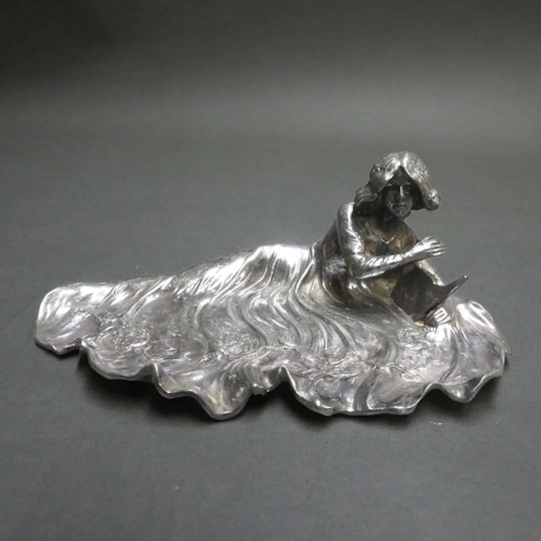 An Art Nouveau silver plated pin dish, the design depicting ...