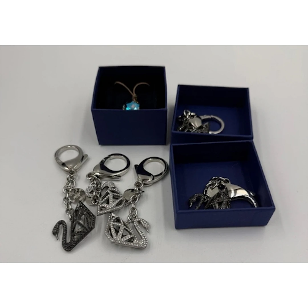 A selection of Swarovski crystal swan keyrings and a pendant...