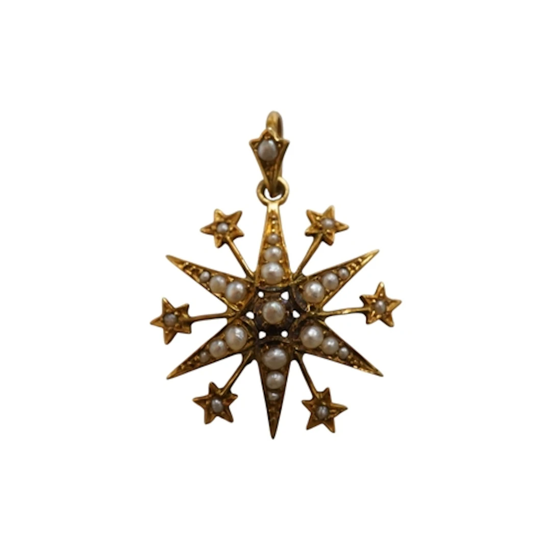 An Edwardian 9ct gold and graduated seed pearl set starburst...