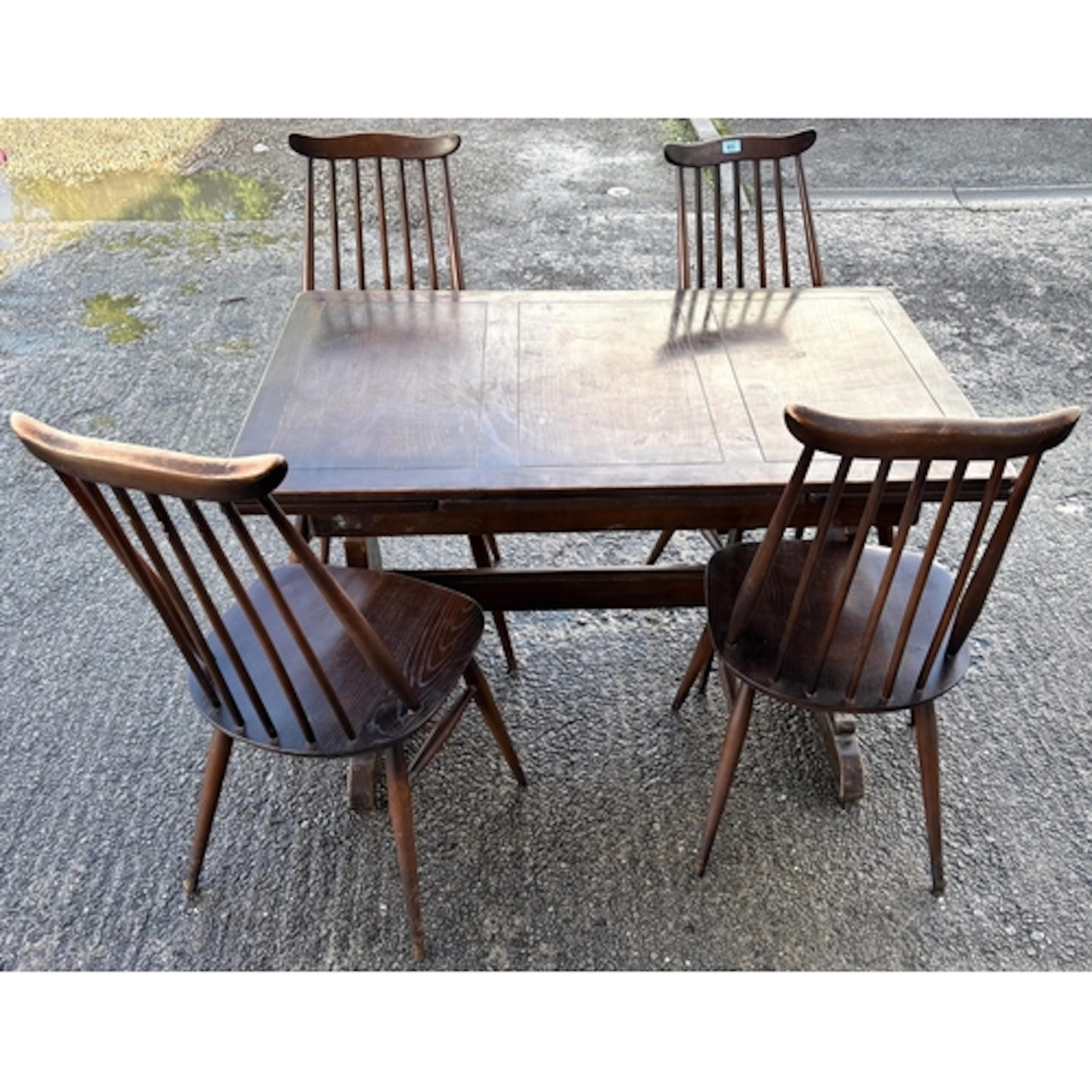 A mid-century Ercol elm dining suite consisting of a drawer-...