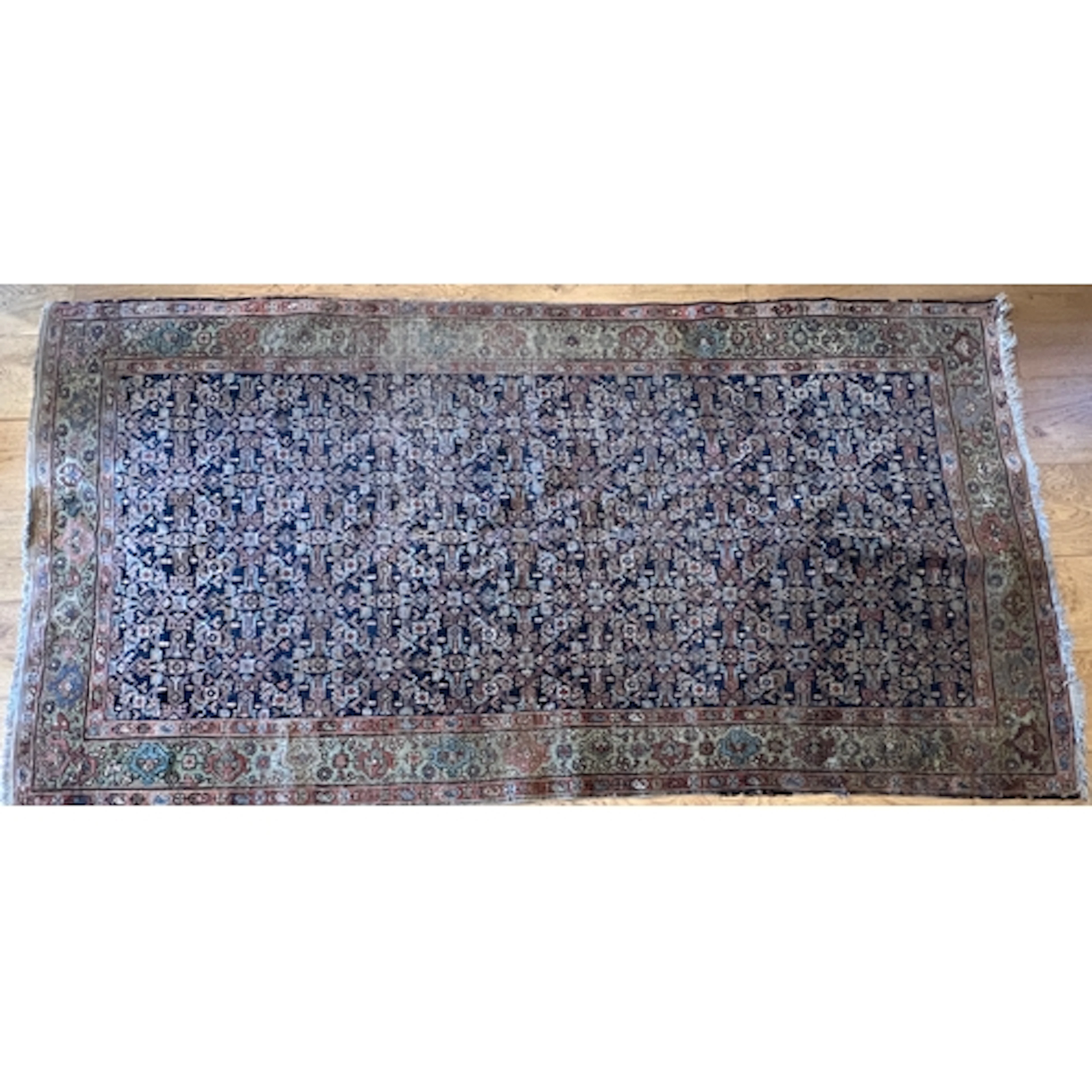 An early 20th century Persian rug, retailed by Harvey Nichol...