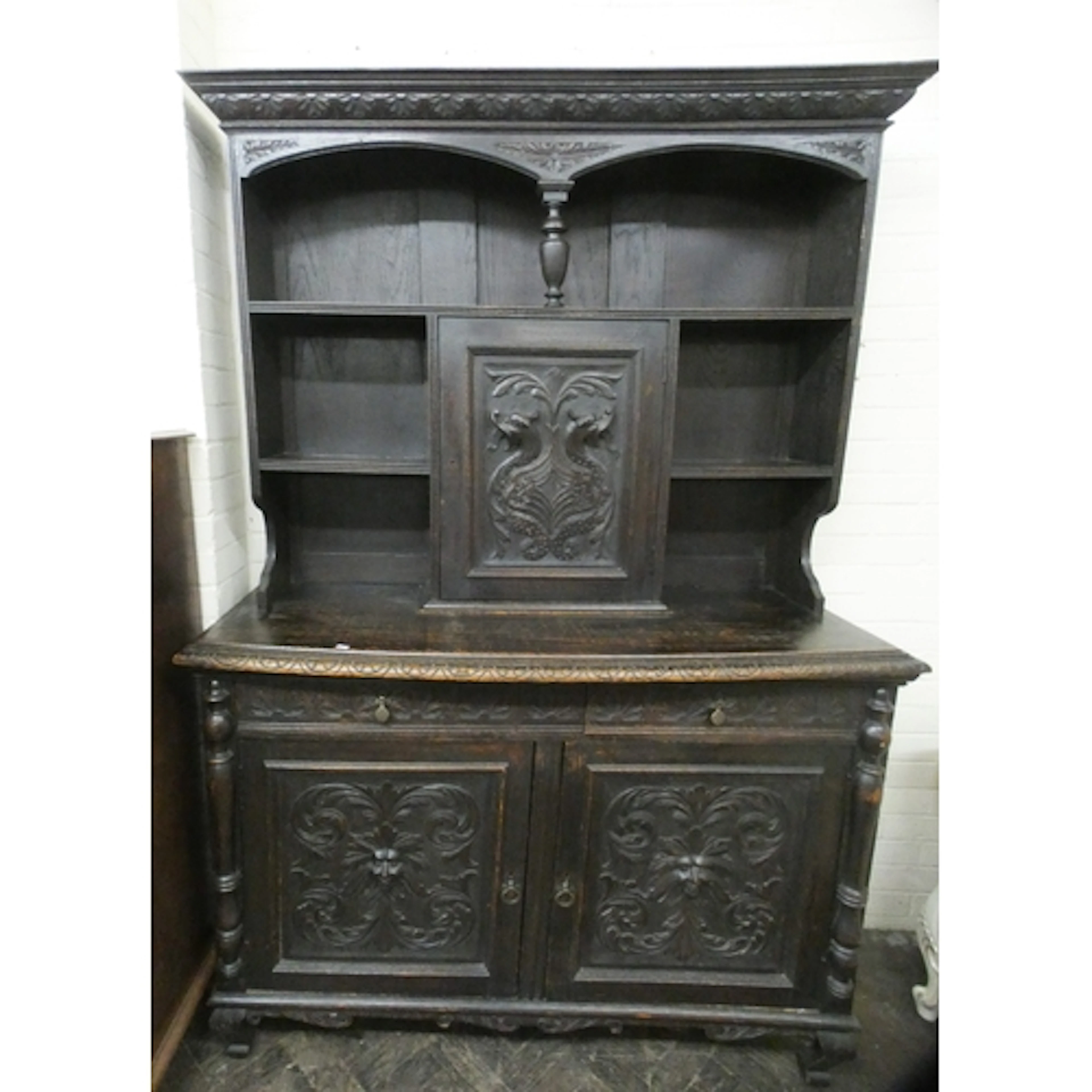 A late Victorian dark oak dresser with Green man carved door...