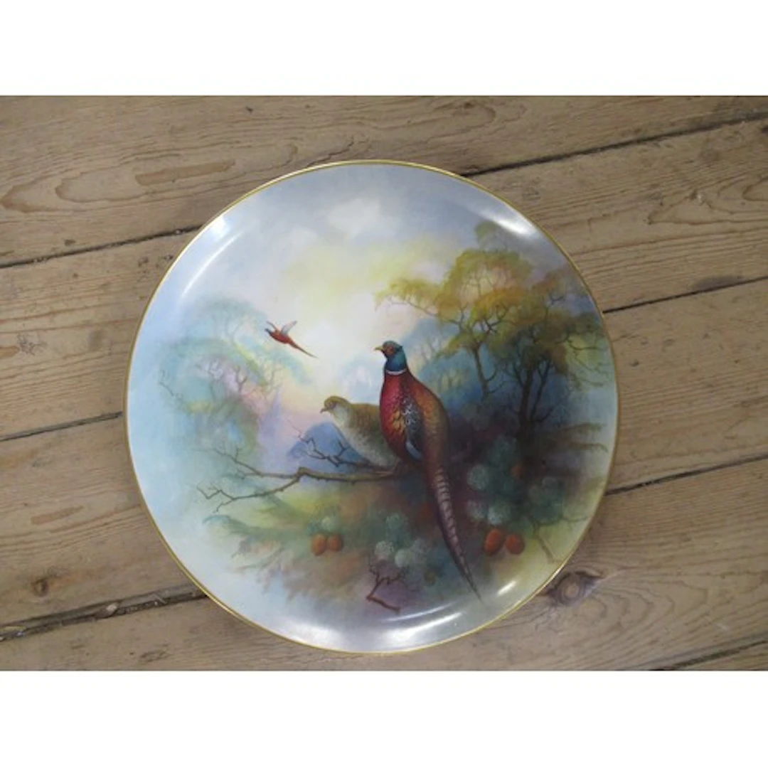 A circular porcelain charger, decorated with pheasants in pi...