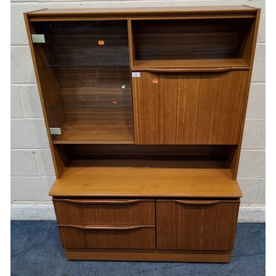 A MID-CENTURY TEAK EFFECT WALL UNIT, the single glass door e...